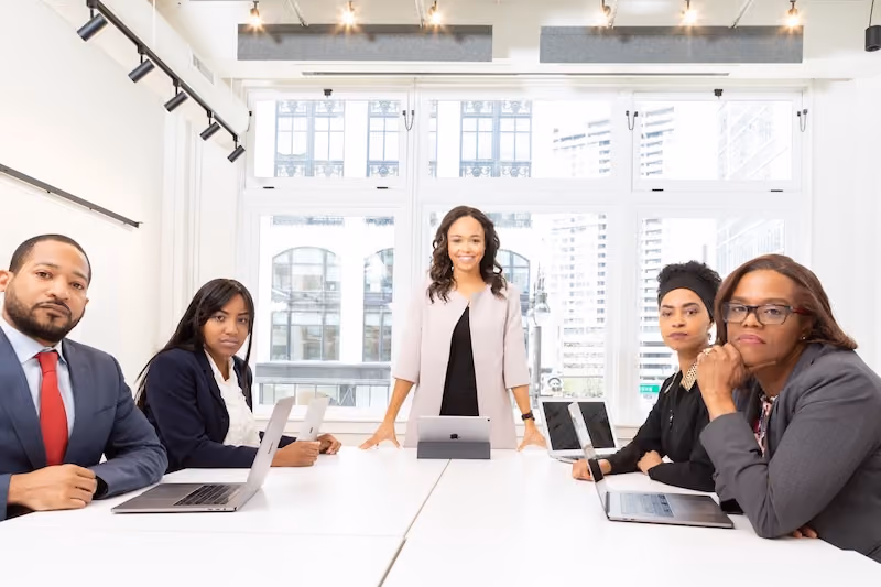 A meeting room with employees sitting at a table