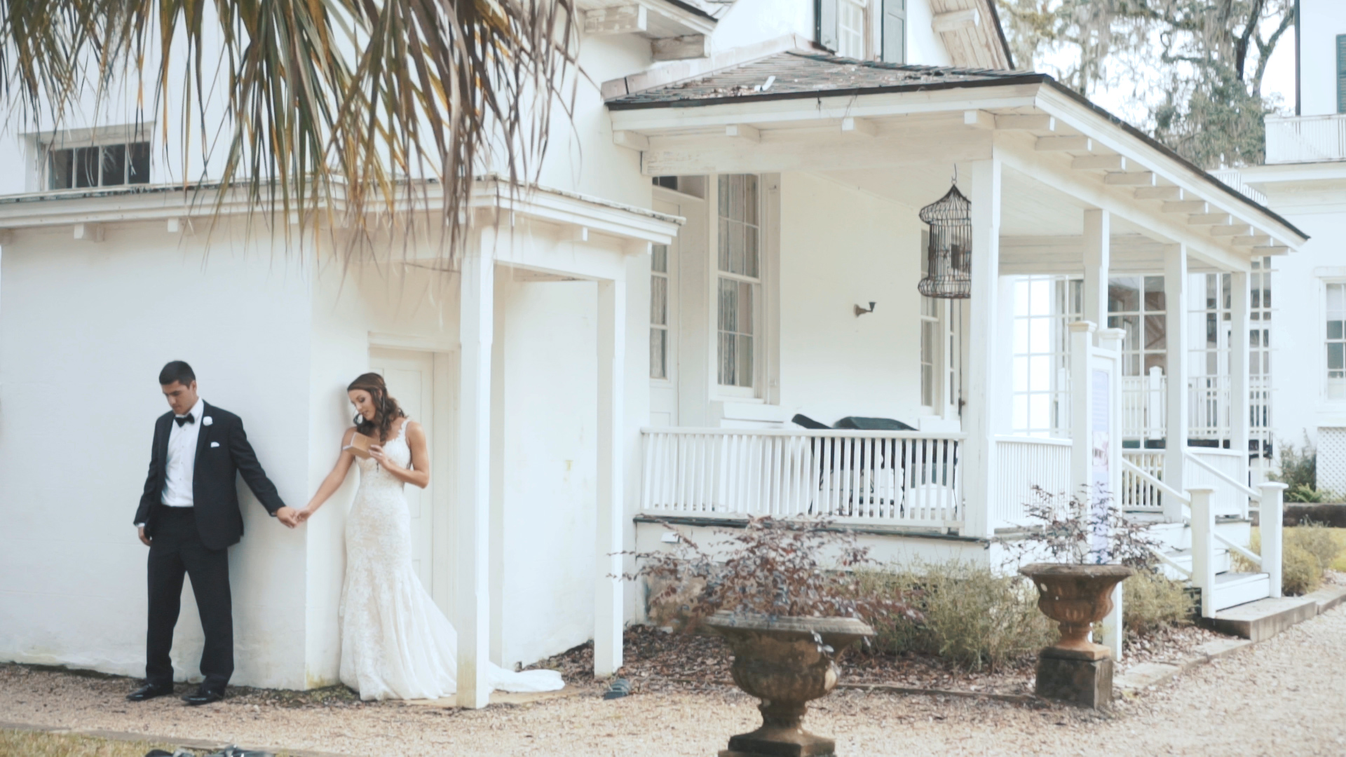 Bride and groom hold hands and read letters to one another during first touch on wedding day.