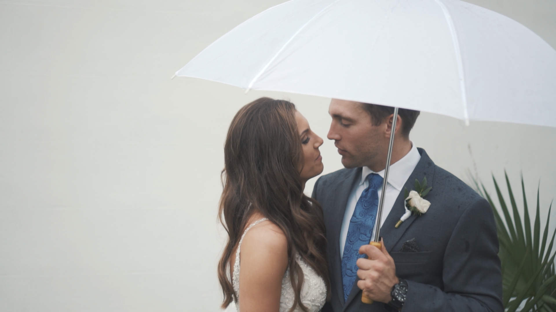 Beautiful bride and groom under umbrella on wedding day - minimalist, artsy shot.