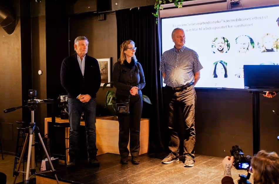 Tre bidragsytere står på scenen