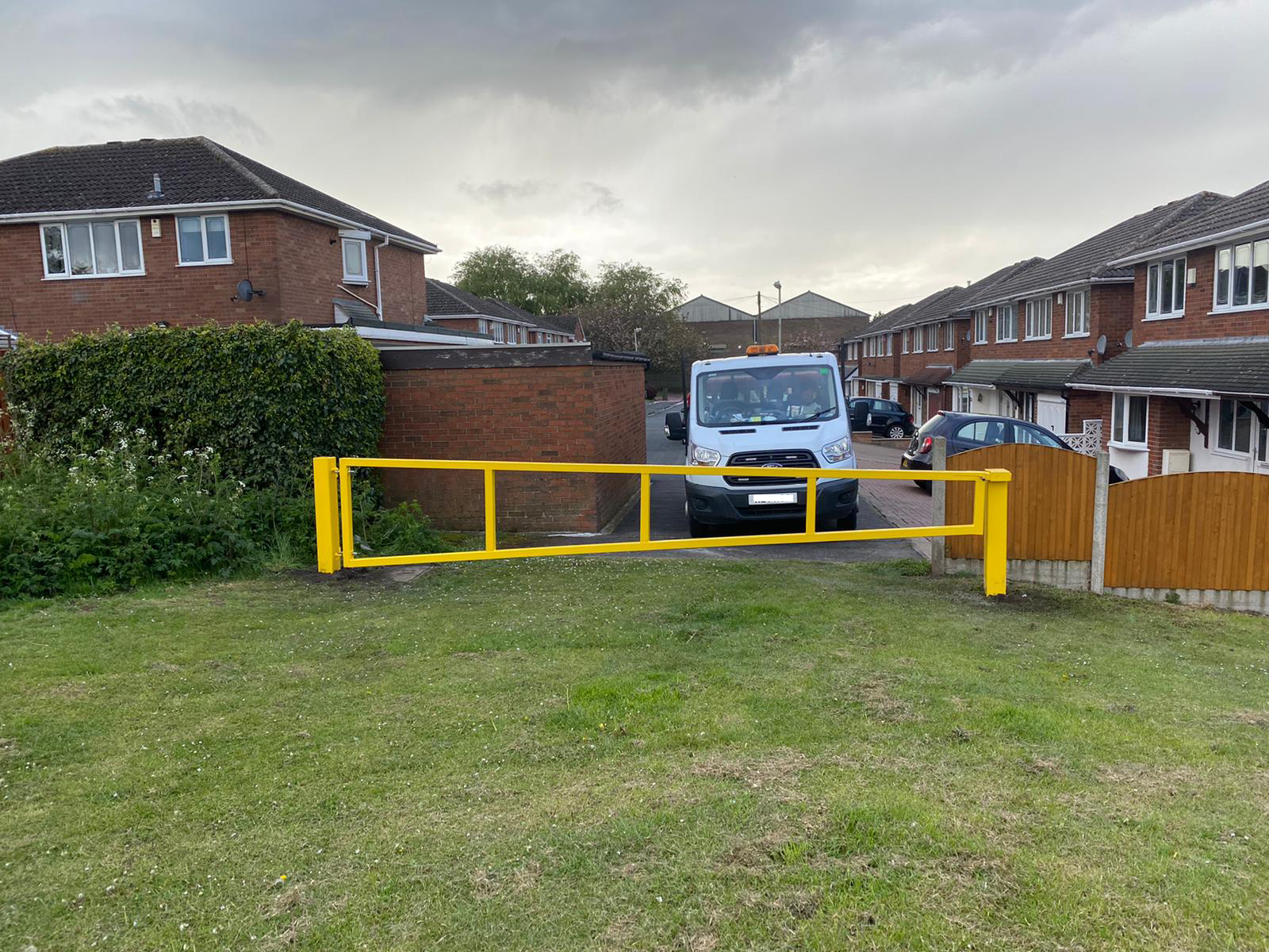 Yellow swing barrier installed by Aremco Barriers for Dudley Council to prevent unauthorised vehicle access to a residential field