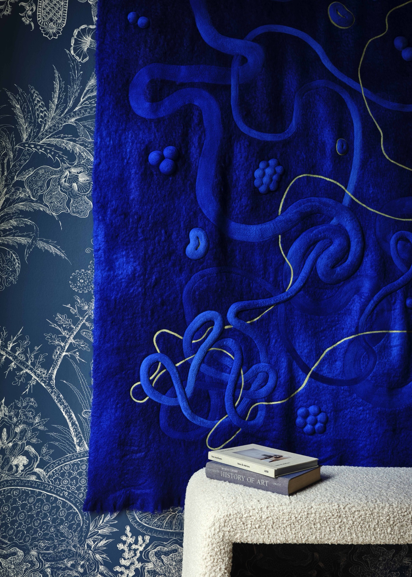 Detail of the wool wallcovering with cream-colored boucle covered bench below.
