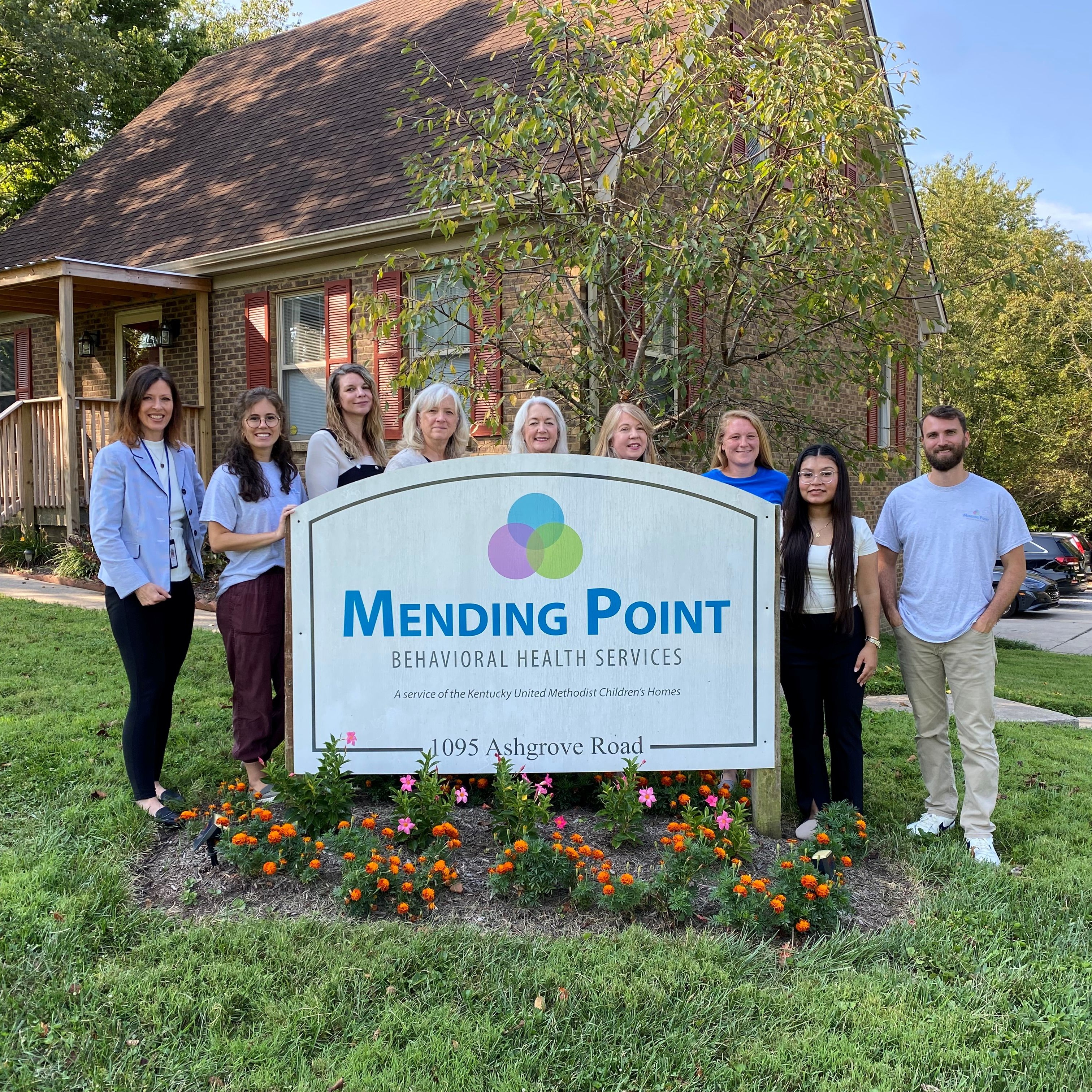 Group photo of staff from Mending Point Behavioral Health Central Kentucky Office in front of the building on KyUMH's Nicholasville Campus.