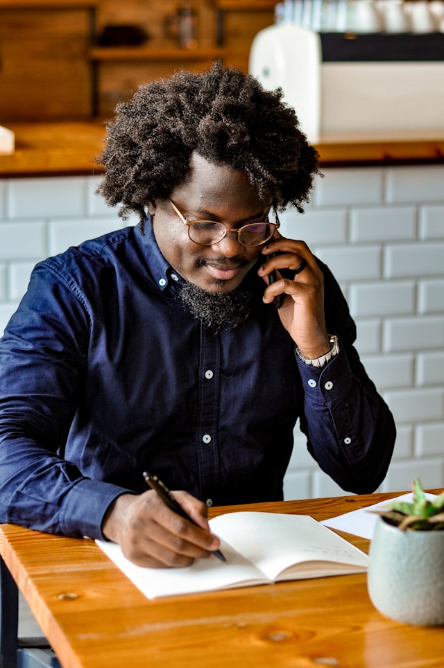Small business owner speaking with a payment provider on the phone while managing daily operations