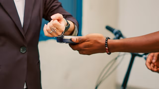 Customer making in-person contactless card payment on a portable payment terminal