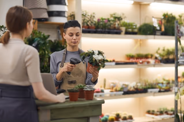 Retail shop owner processing an in-person sale at a UK small business using point of sale technology