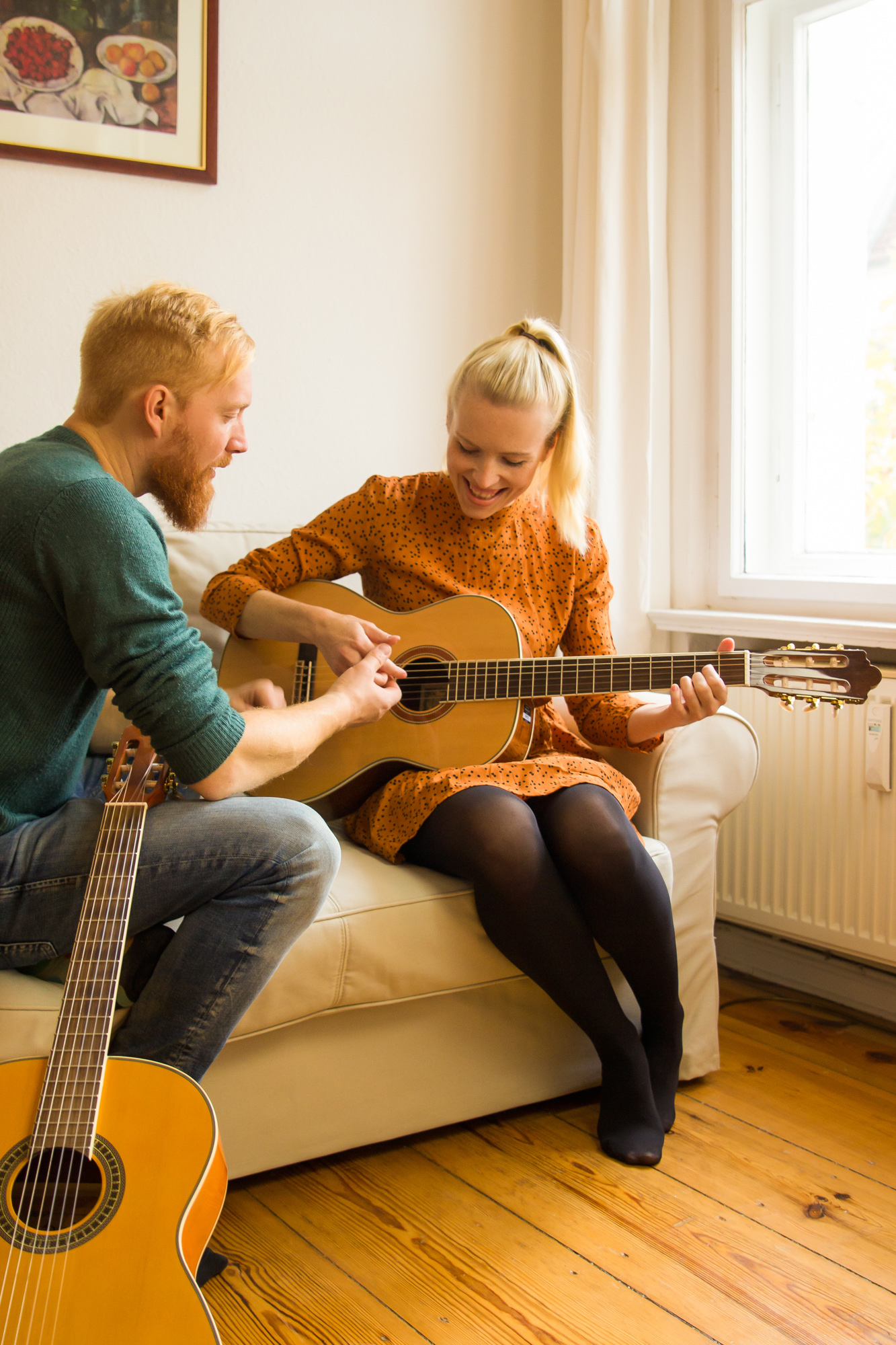 Gitarrenunterricht Berlin Wilmersdorf – persönliche Gitarrenstunde auf dem Sofa bei Greifmusic, Lehrkraft zeigt Schülerin einen Akkord