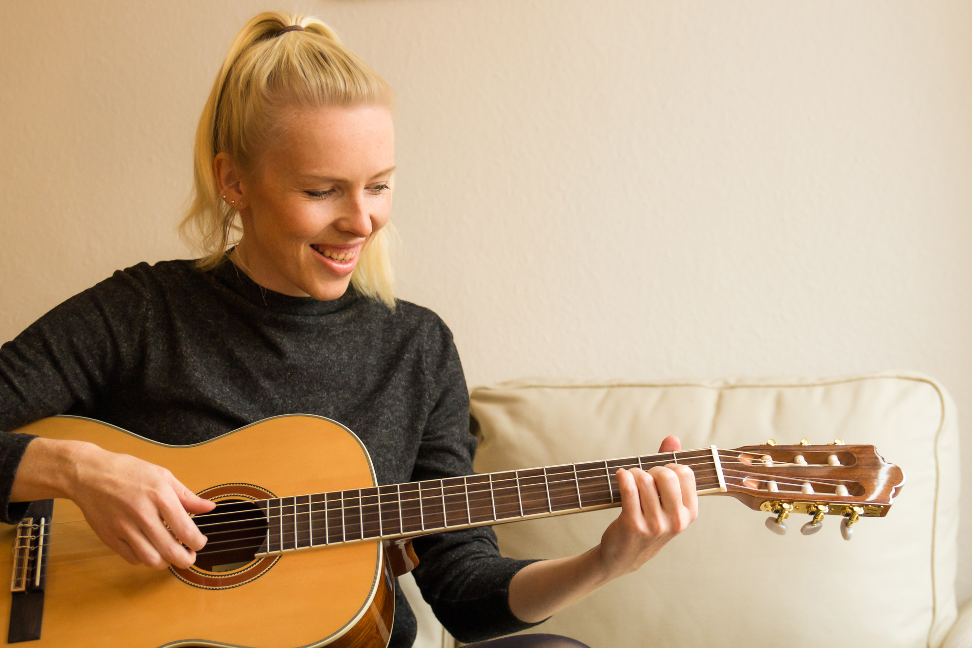 Gitarristin spielt entspannt Gitarre beim Gitarrenunterricht in Berlin Steglitz