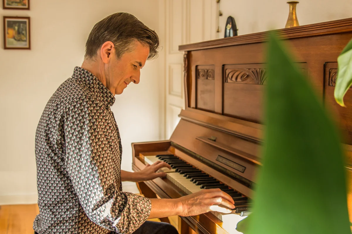 Ein Erwachsener spielt an einem akustischen Klavier.