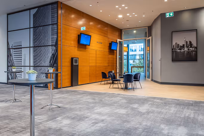 Modern conference room with wood wall, tables with chairs, and cityscape photo on gray wall.