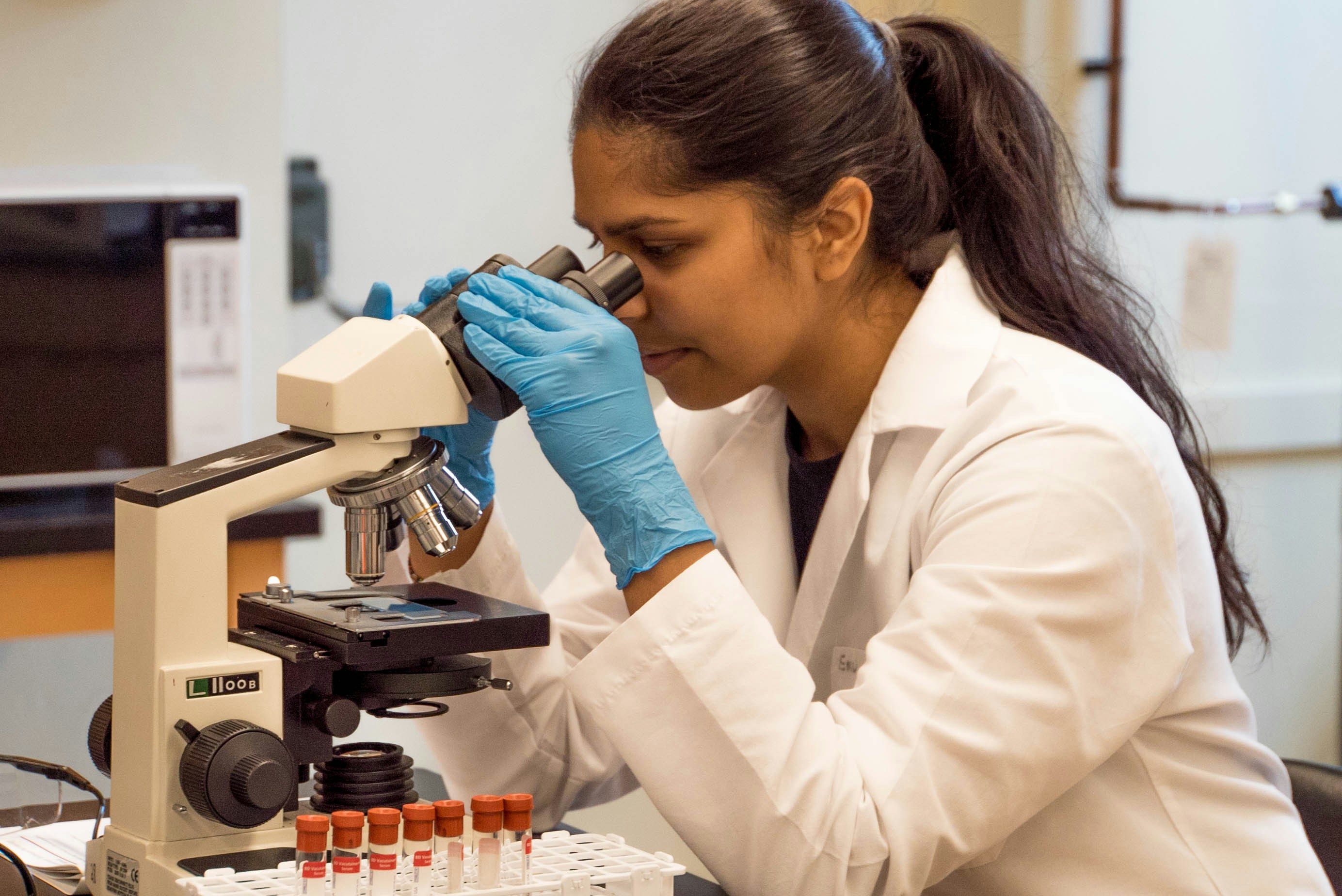 R&D scientist reviewing formulation data trends and charts on a monitor
