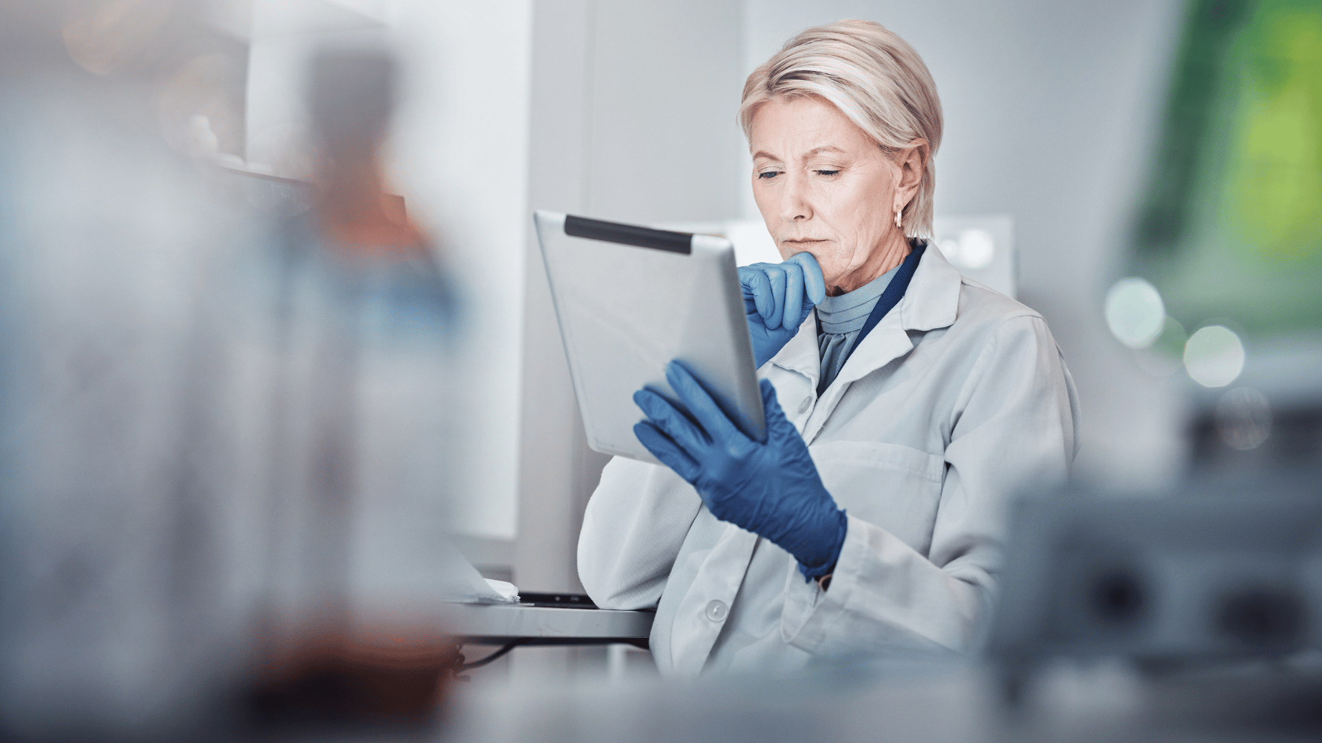Scientist reviewing an electronic laboratory record on a computer, representing audit trails, electronic signatures, and controlled data in a regulated ELN.