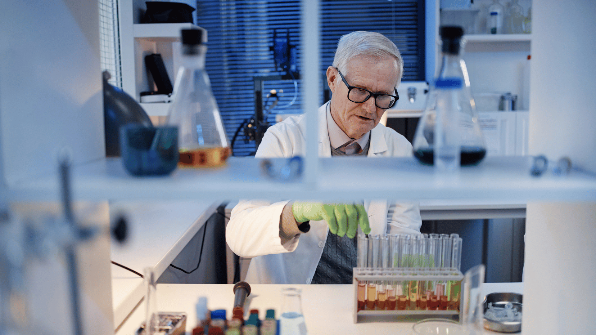 Scientist examines test tubes.