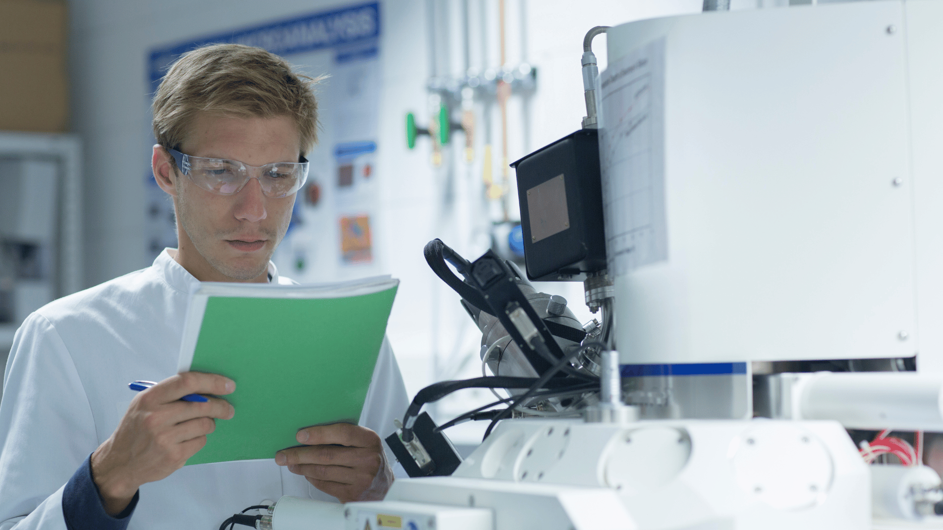 A laboratory technician cross-checking a calibration record against a piece of test equipment