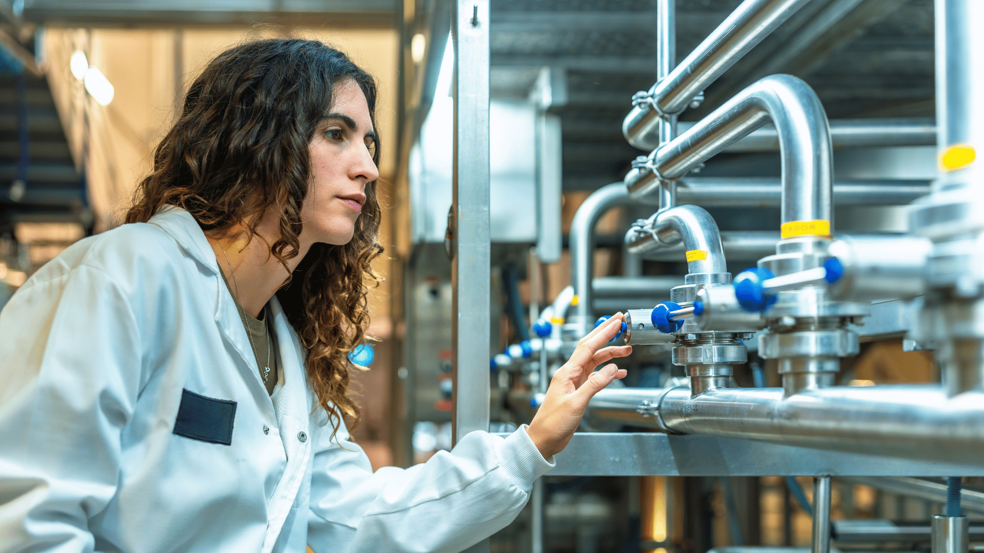 Process engineer reviews production sensor trends in a petrochemical plant control room.