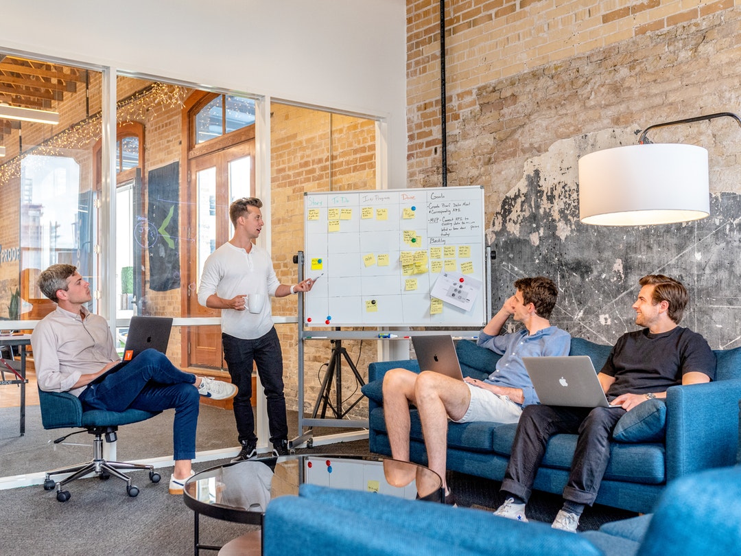 Stock image of tech bros doing tech bro things at white board.