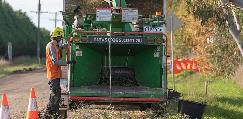 An arborist setting up our woodchipper to clear the waste we generate after a job.