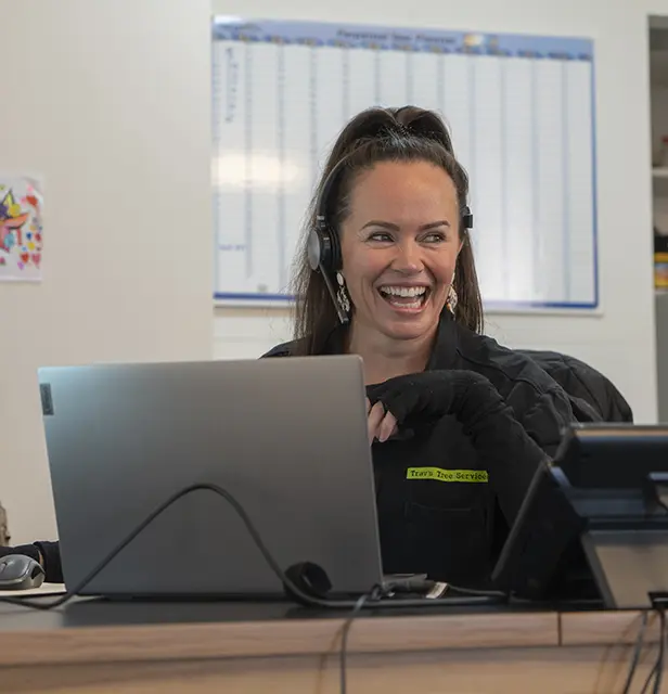 Friendly customer service representative assisting clients at a professional tree services company.