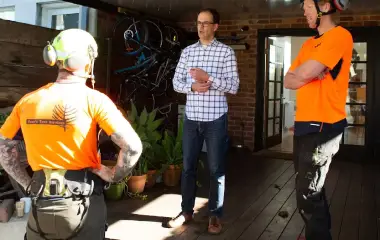 Our arborists chatting to a client in his backyard. They’re discussing the best way to secure a tree in the backyard.