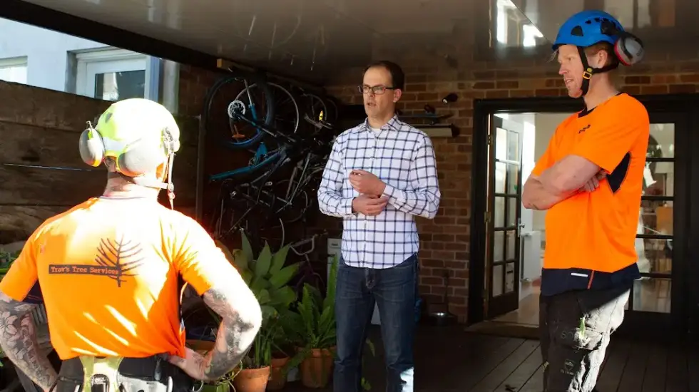 Our arborists chatting to a client in his backyard. They’re discussing the best way to secure a tree in the backyard.