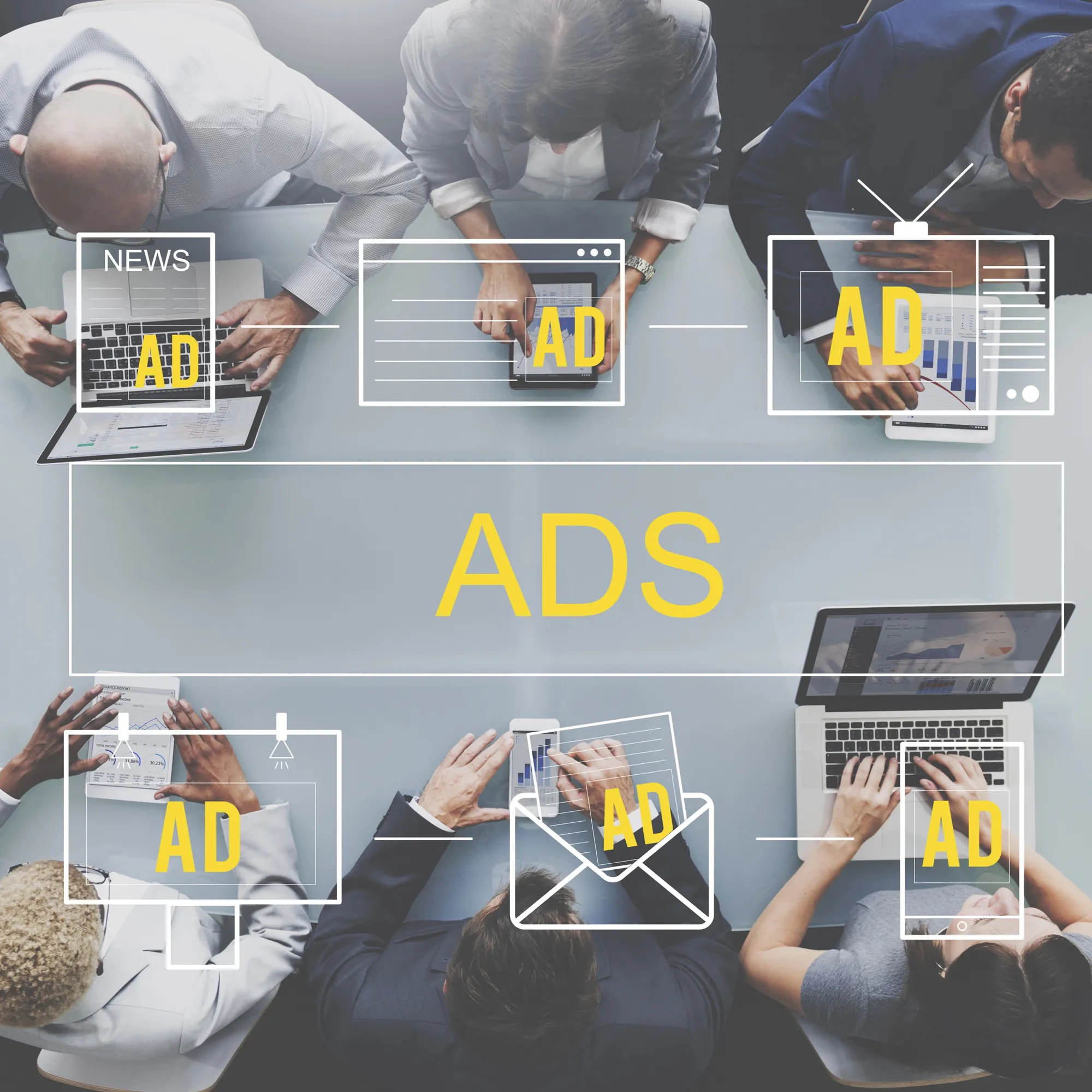 Overhead view of a business team analyzing digital advertising icons and data on laptops and tablets at a conference table