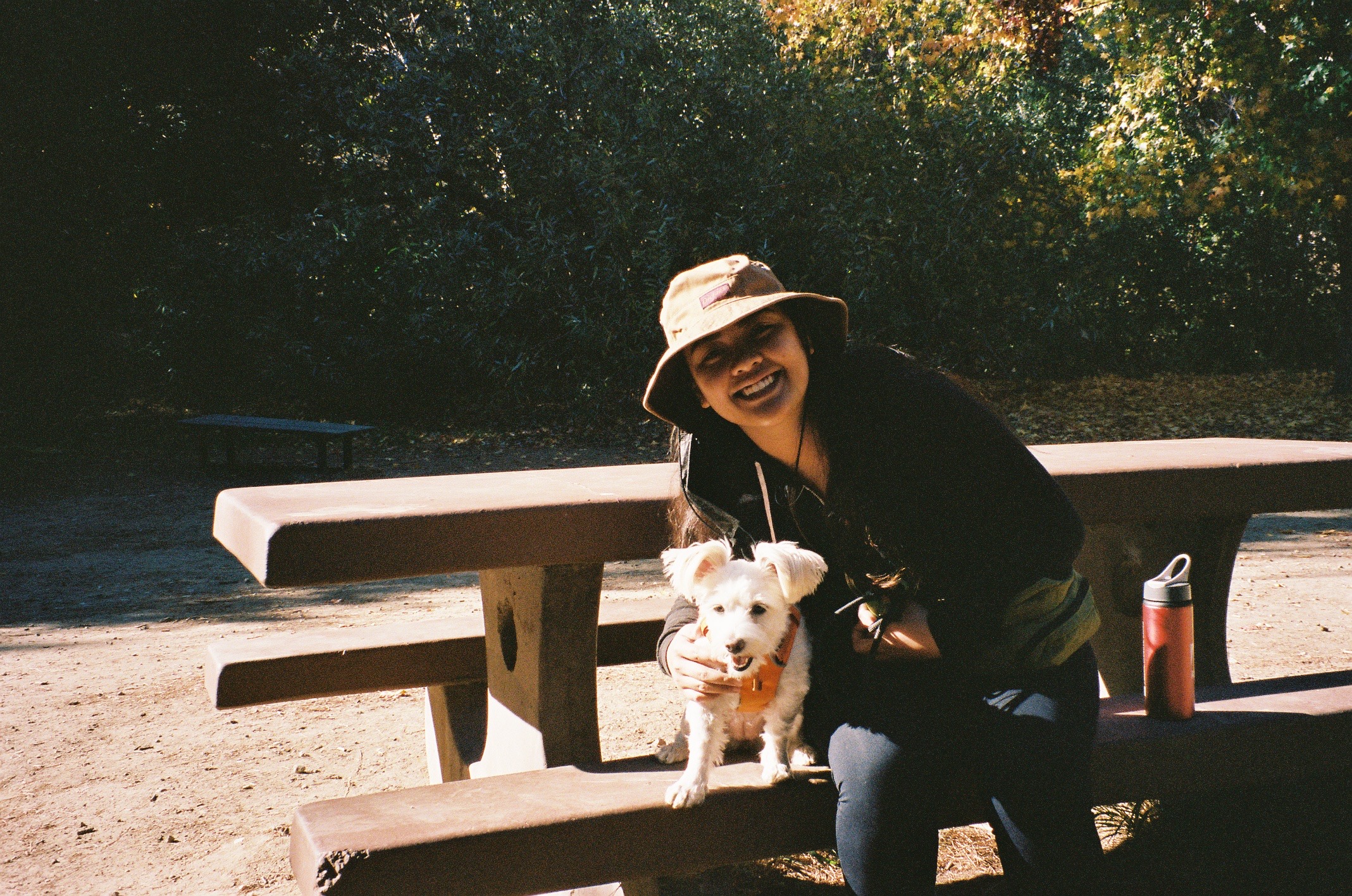 Kayla sitting on a bench with her dog Tofu
