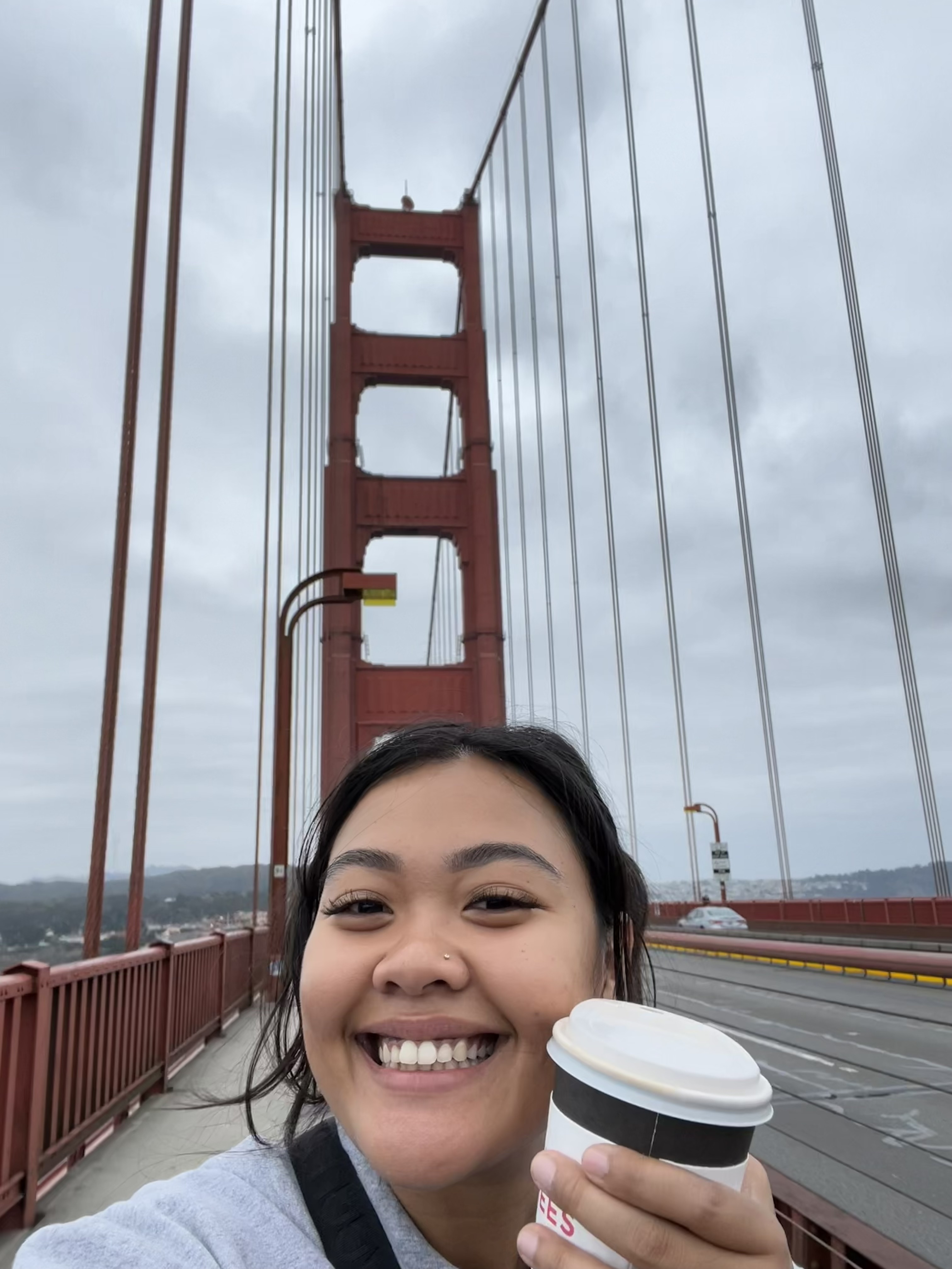 Kayla walking the Golden Gate Bridge with a coffee in hand