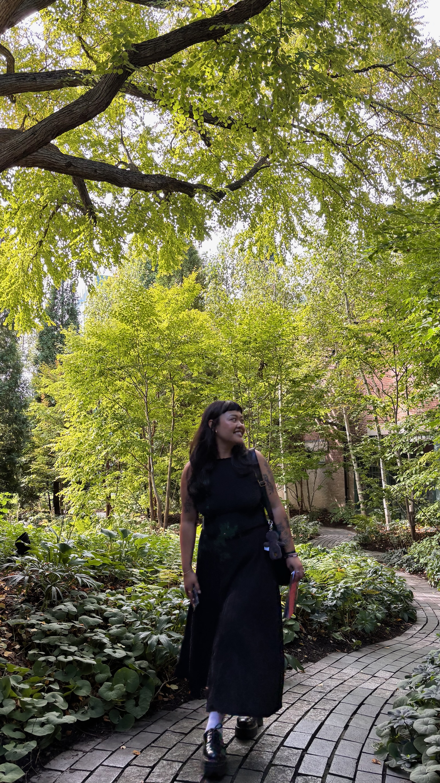 Kayla walking under tall trees