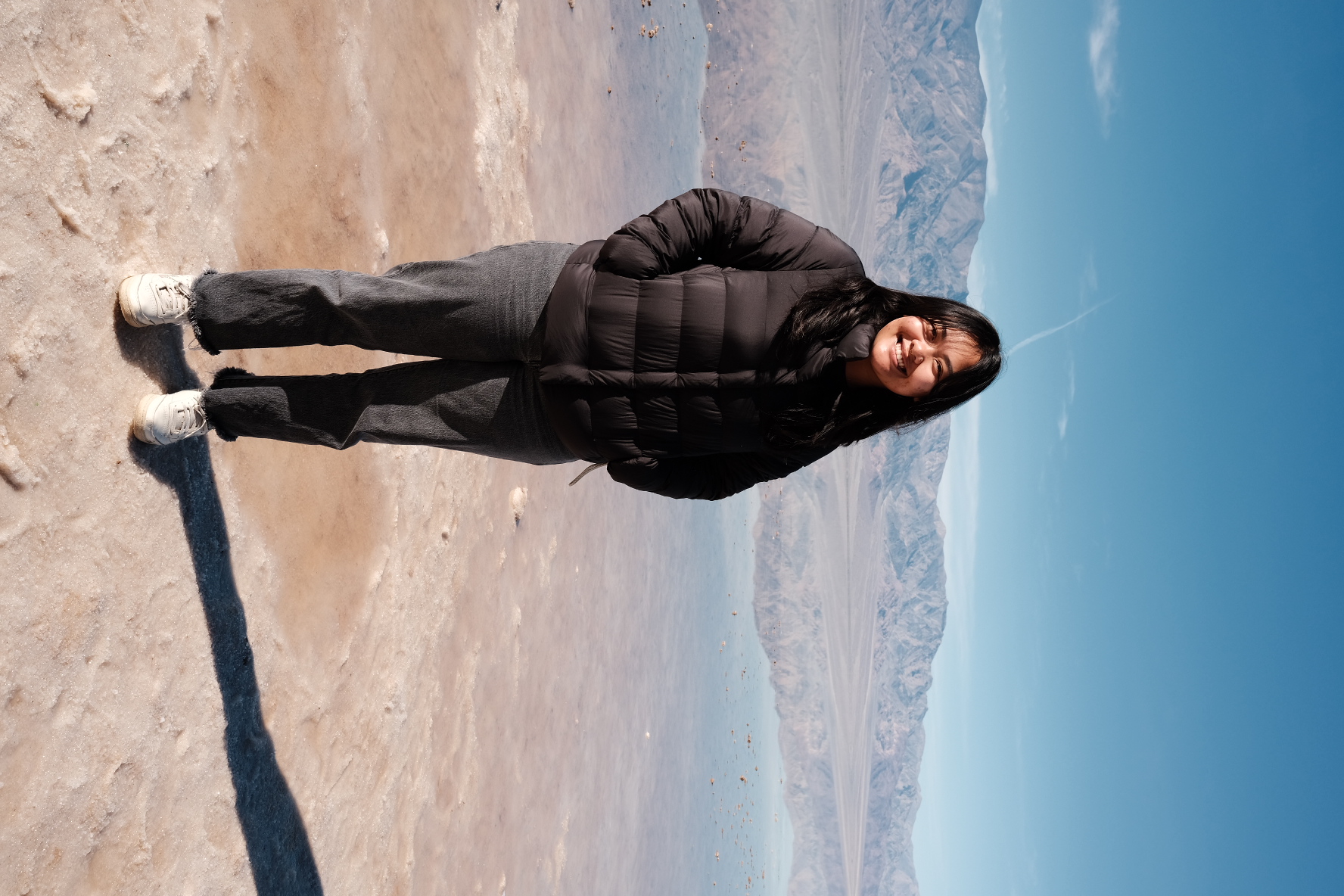 Kayla standing on clear water at Badwater Basin in Death Valley National Park
