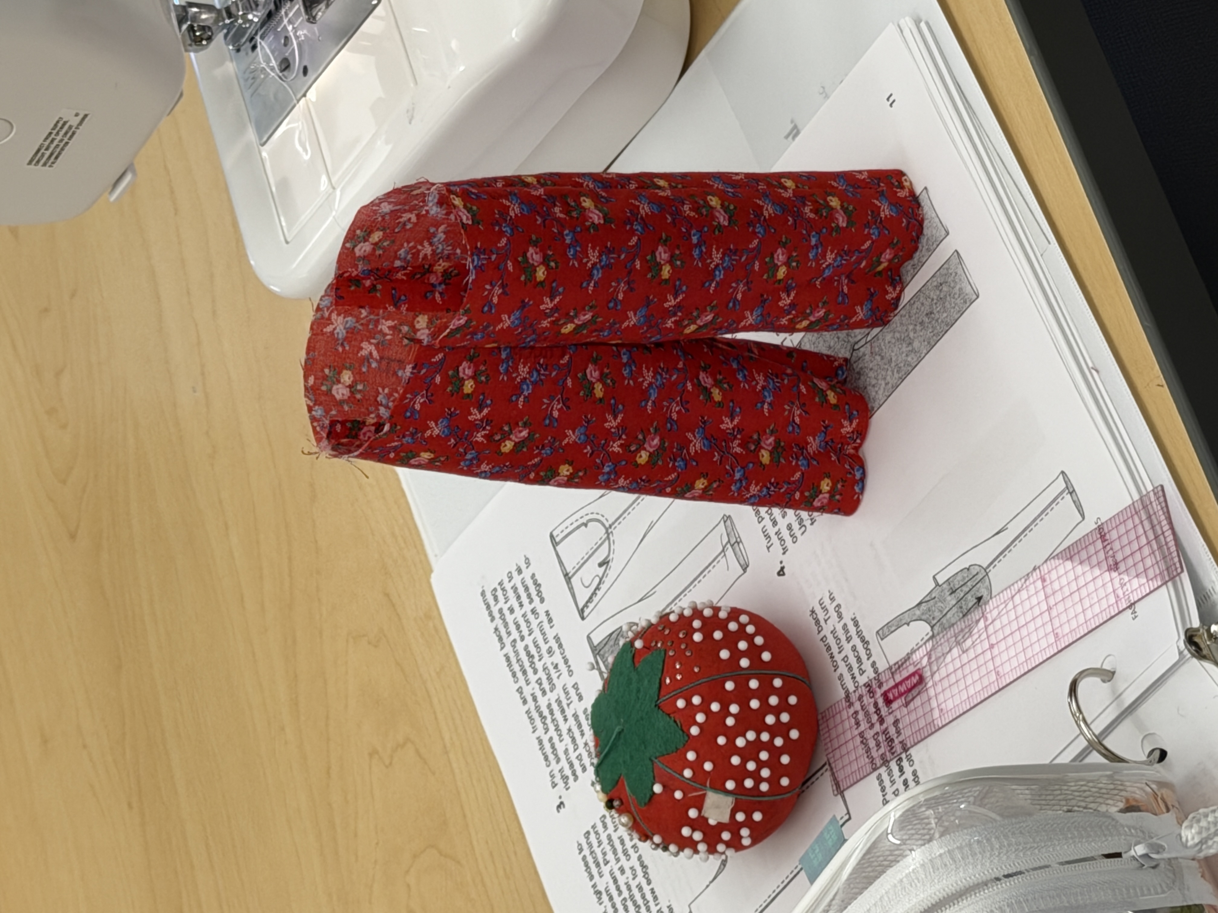 Sewn miniature pants next to a sewing machine