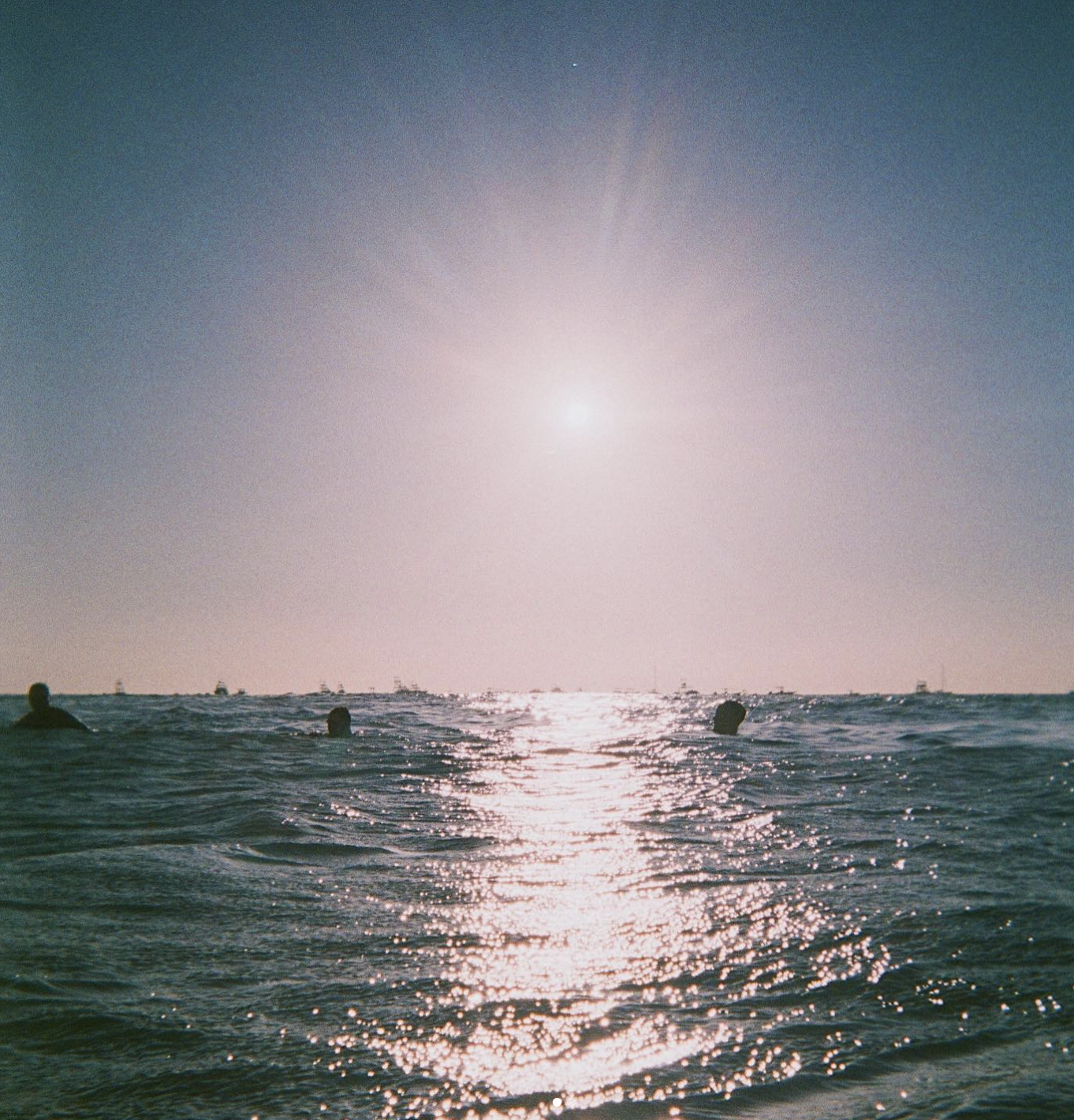 Ocean at sunrise with swimmers