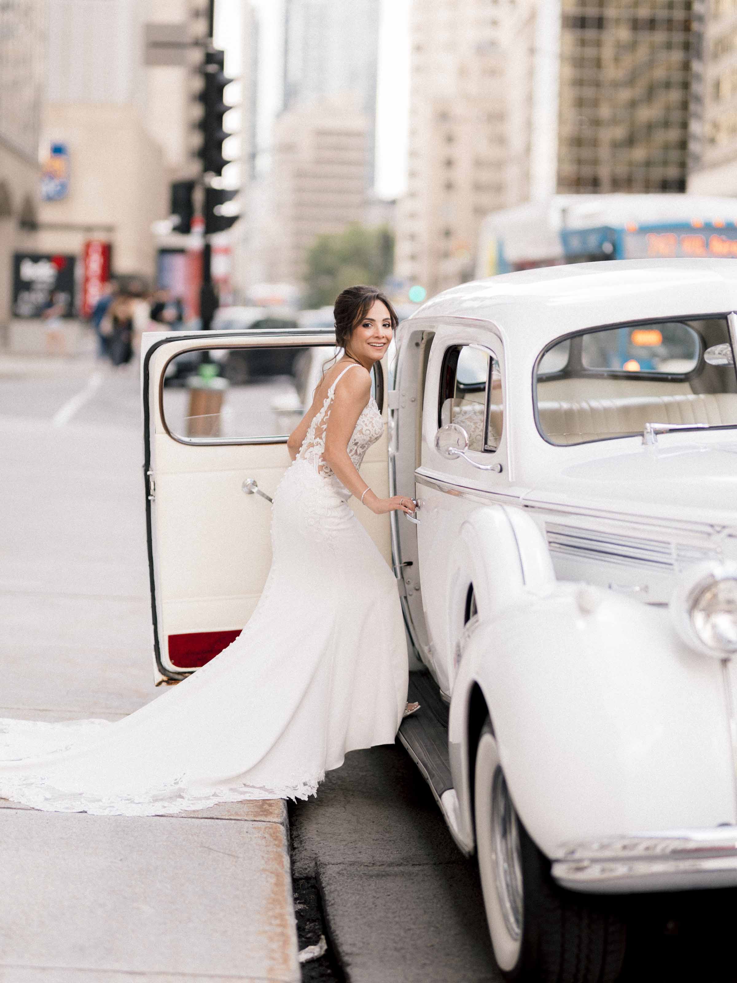 Bride beside a white vintage car on a downtown street, Montréal