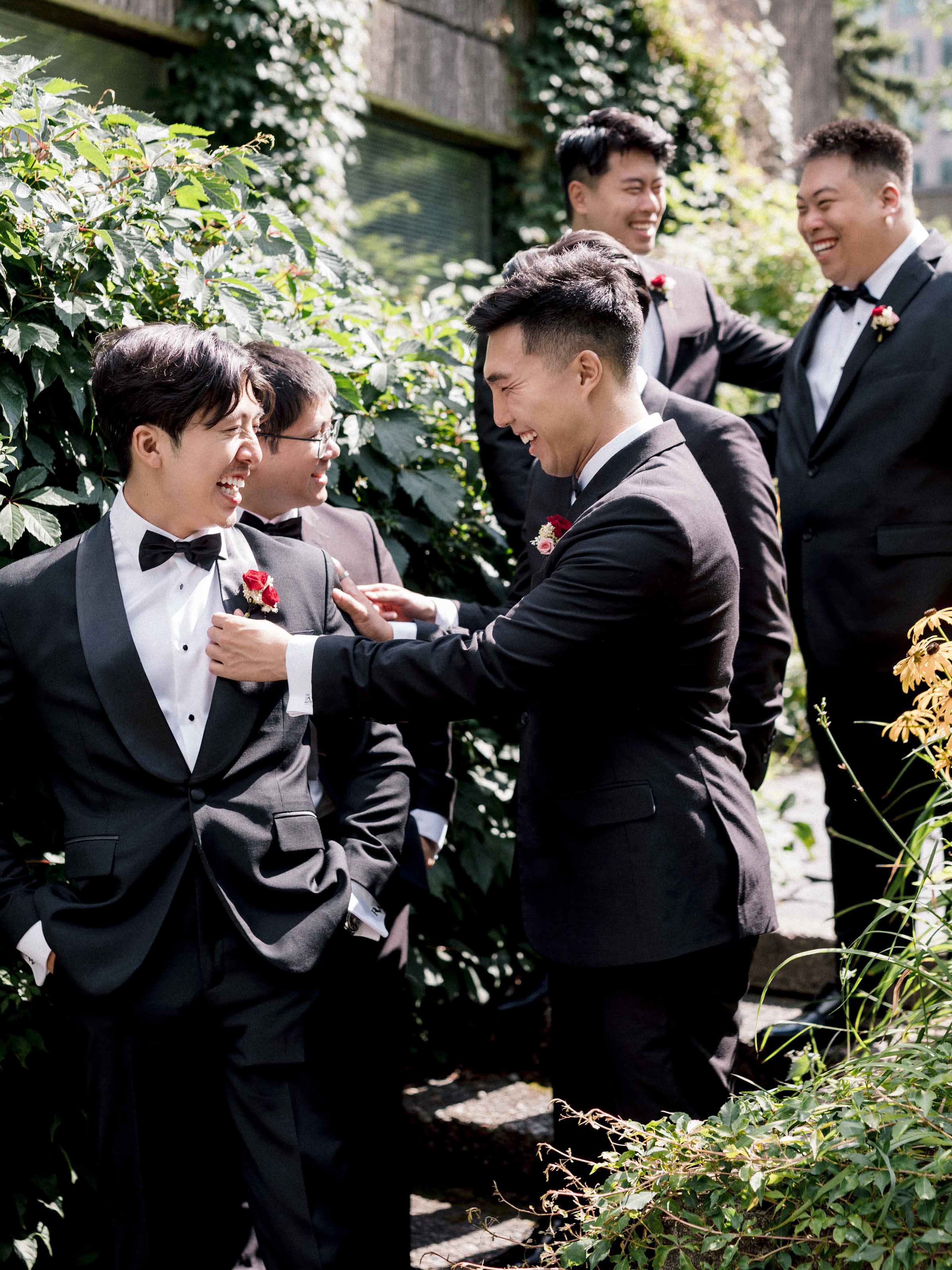 Garçons d'honneur épinglant la boutonnière du marié dans un jardin, Montréal