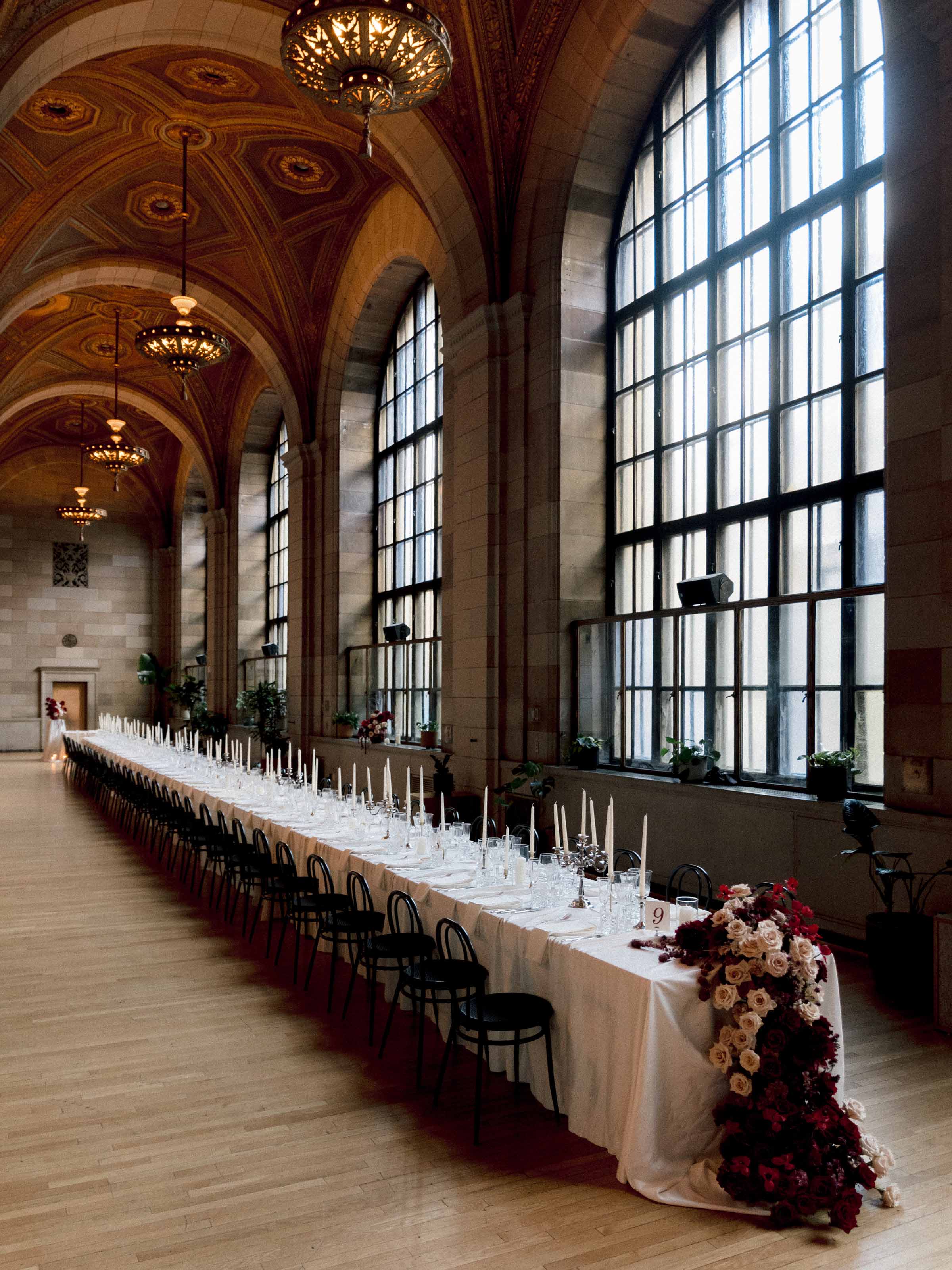 Longue table de banquet sous un plafond peint et de hautes fenêtres, Montréal