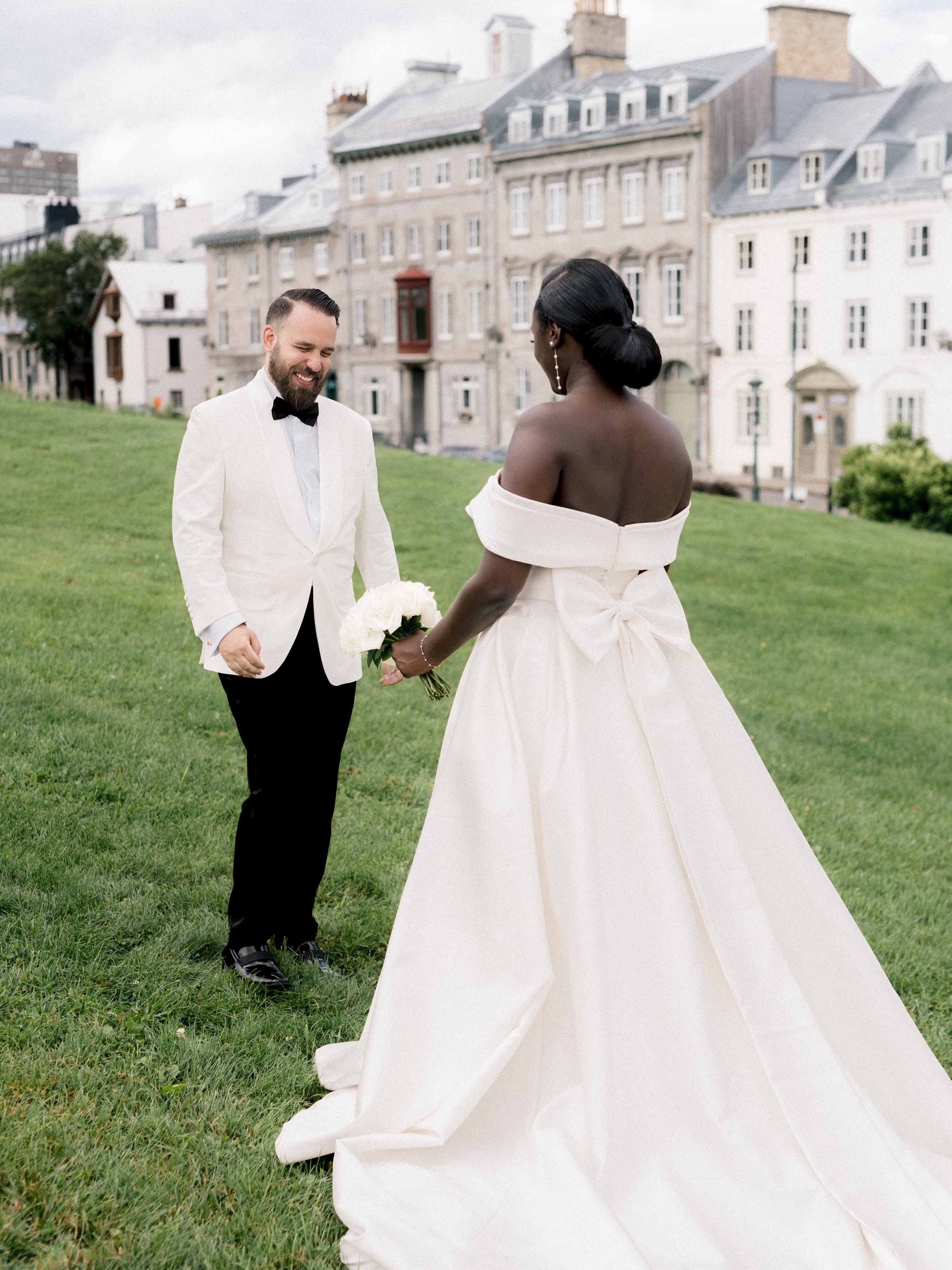 Couple sur la pelouse devant une grande façade pâle, Québec