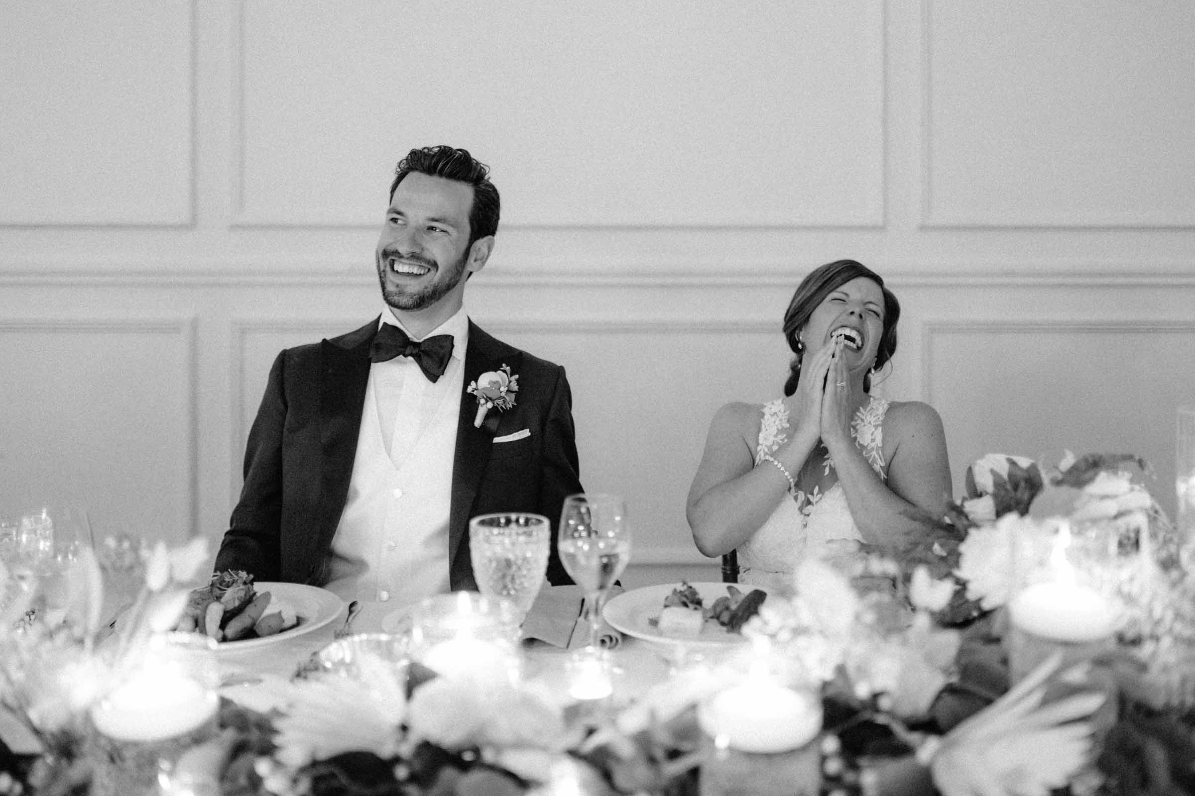 Couple riant à la table d'honneur pendant un discours, noir et blanc, Fairmont Le Manoir Richelieu, La Malbaie