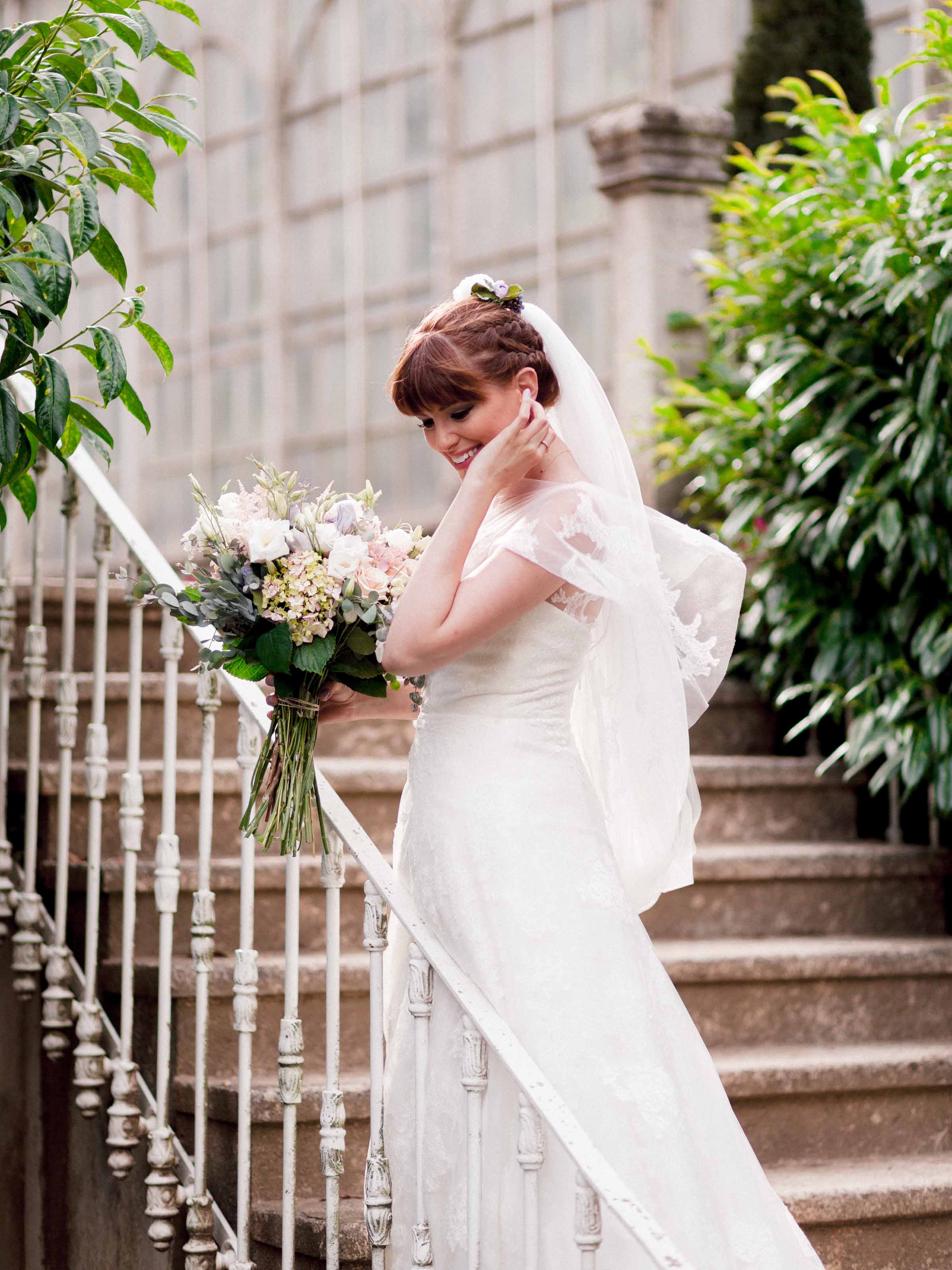 Bride with her bouquet on an ornate staircase, Maslak Kasrı, Istanbul