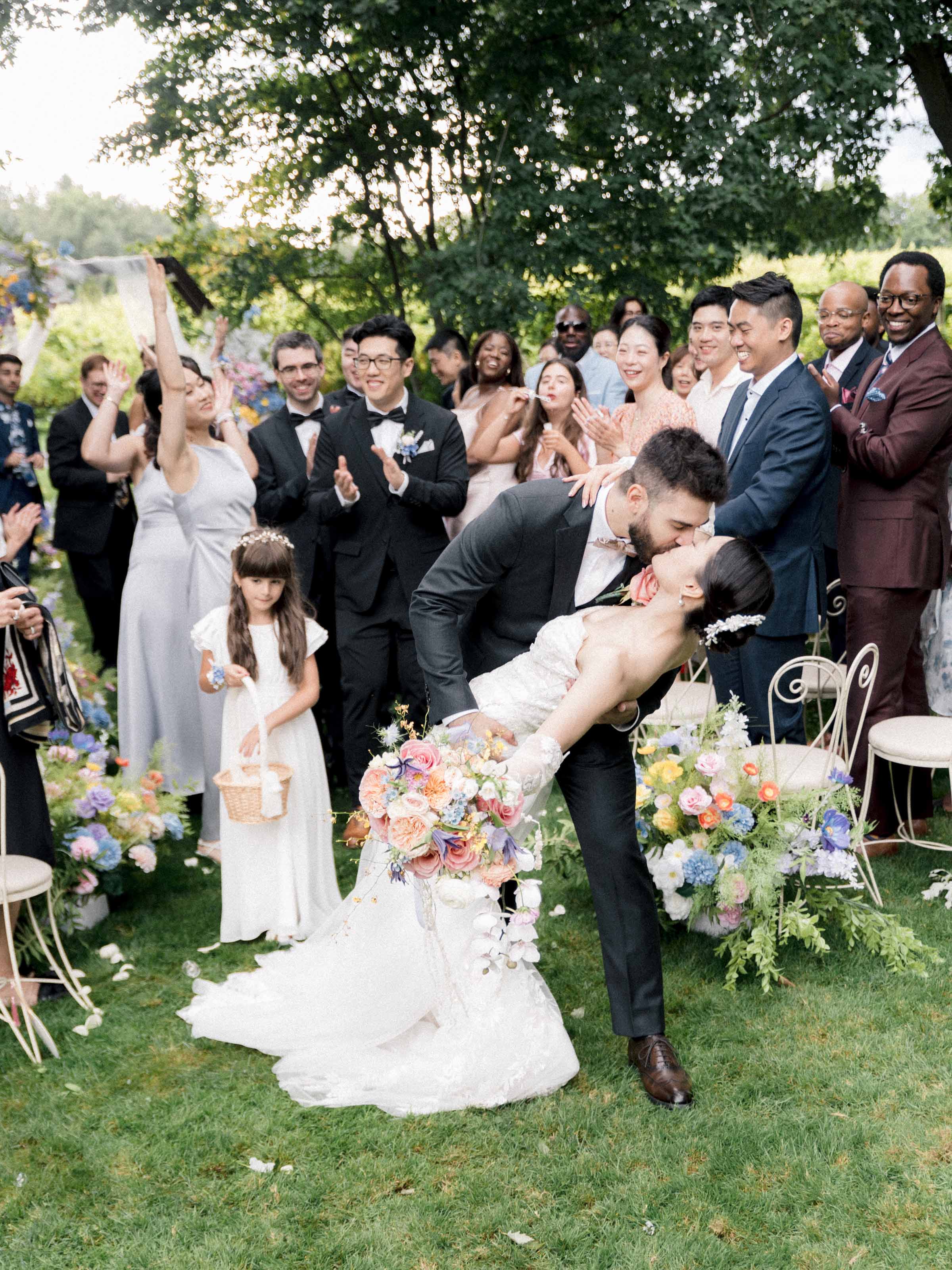 Groom dipping his bride for a kiss as their guests applaud, Montréal