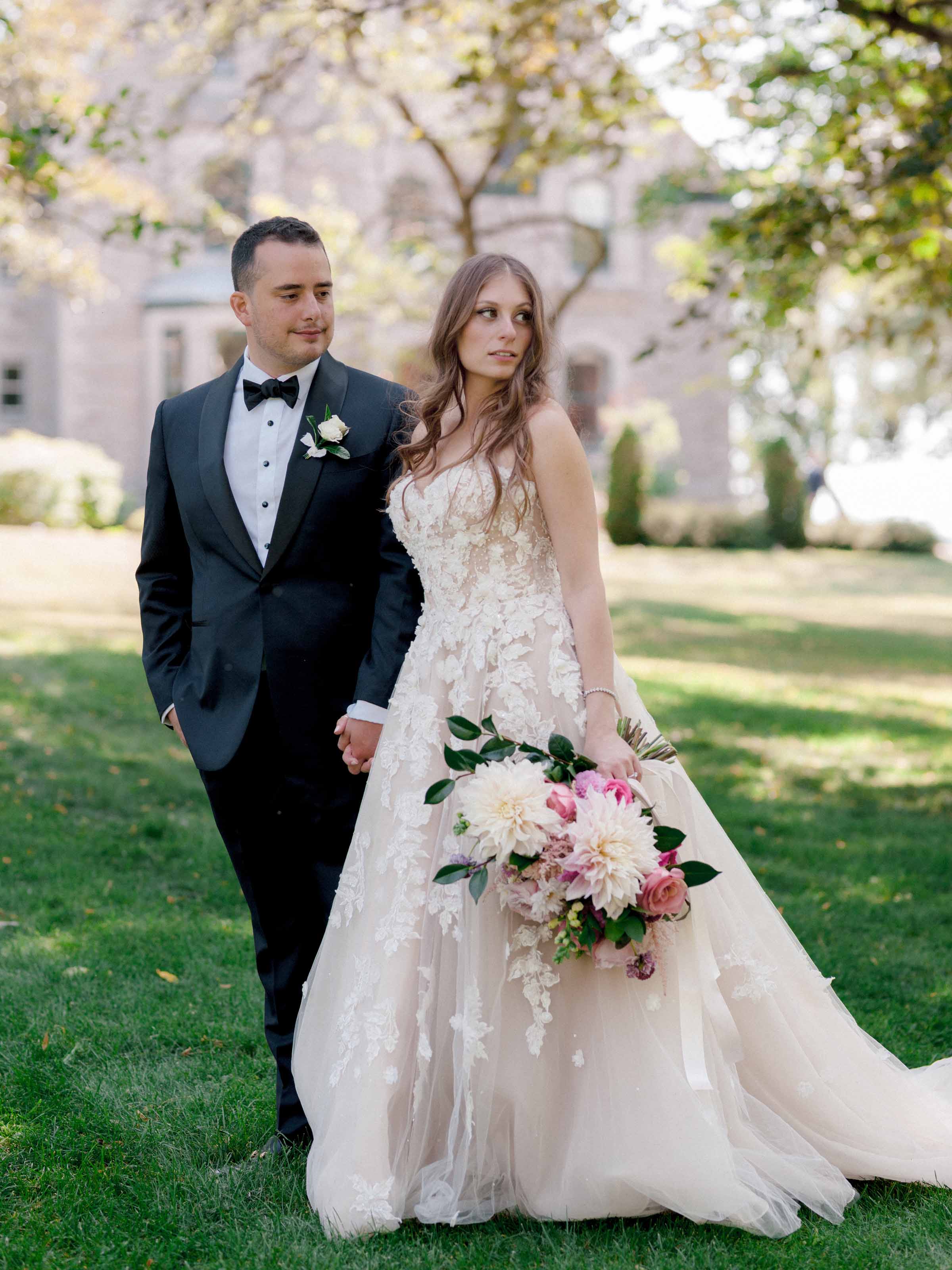Mariés marchant sur la pelouse avec un bouquet aux tons blush et blanc, Montréal