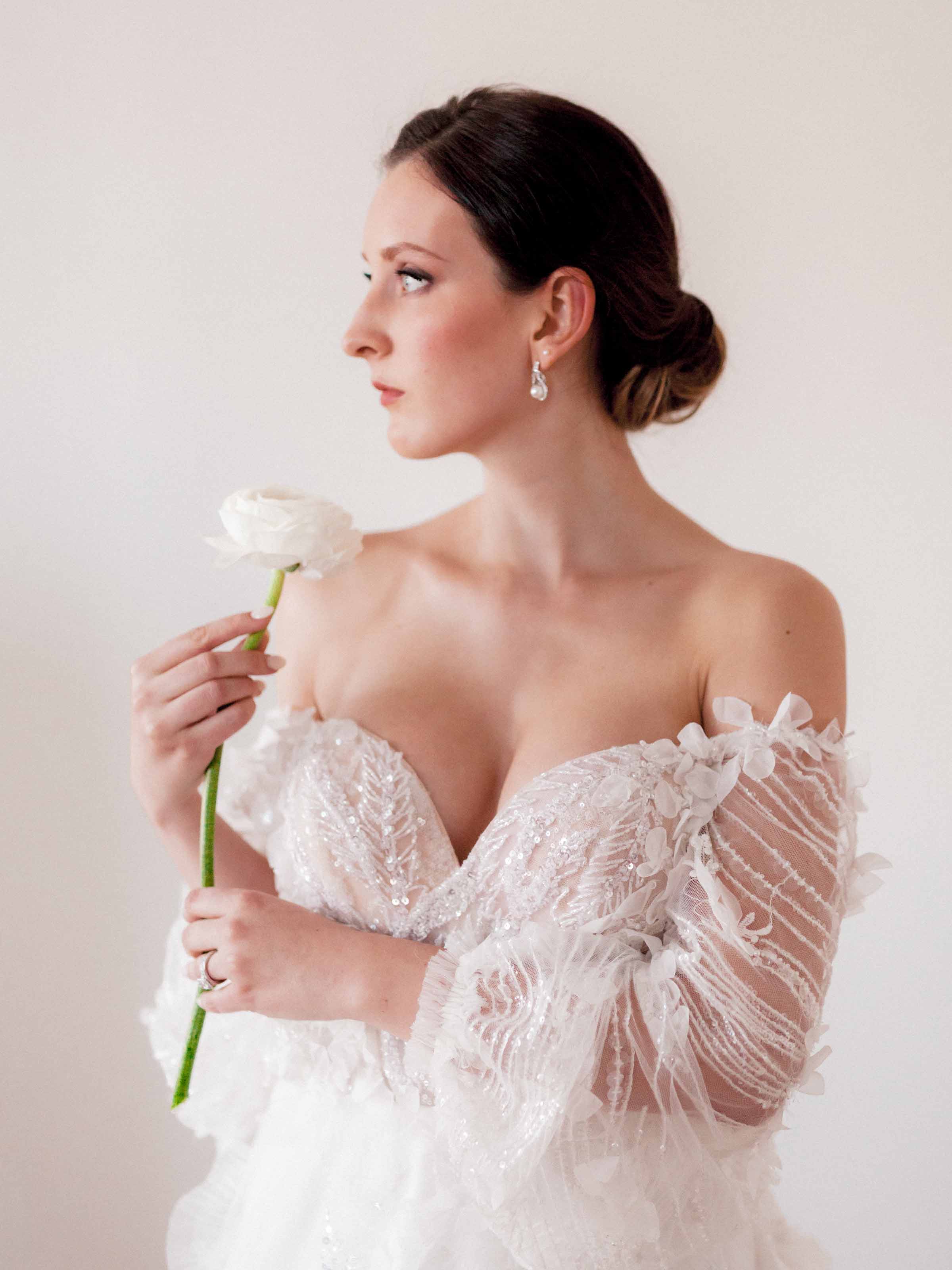 Bride in profile holding a single ranunculus, Quebec City