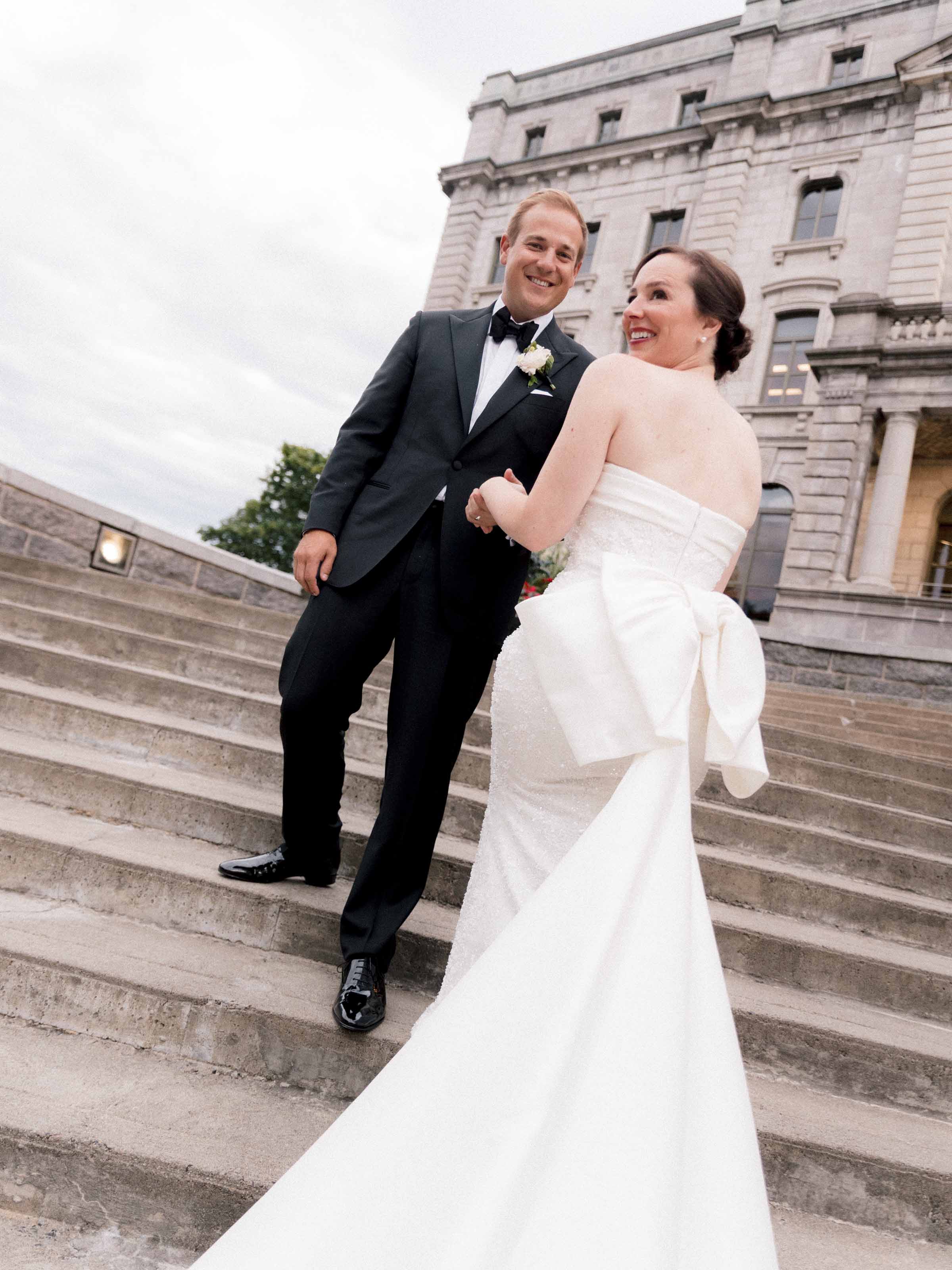 Bride and groom laughing on grand stone steps, Québec City