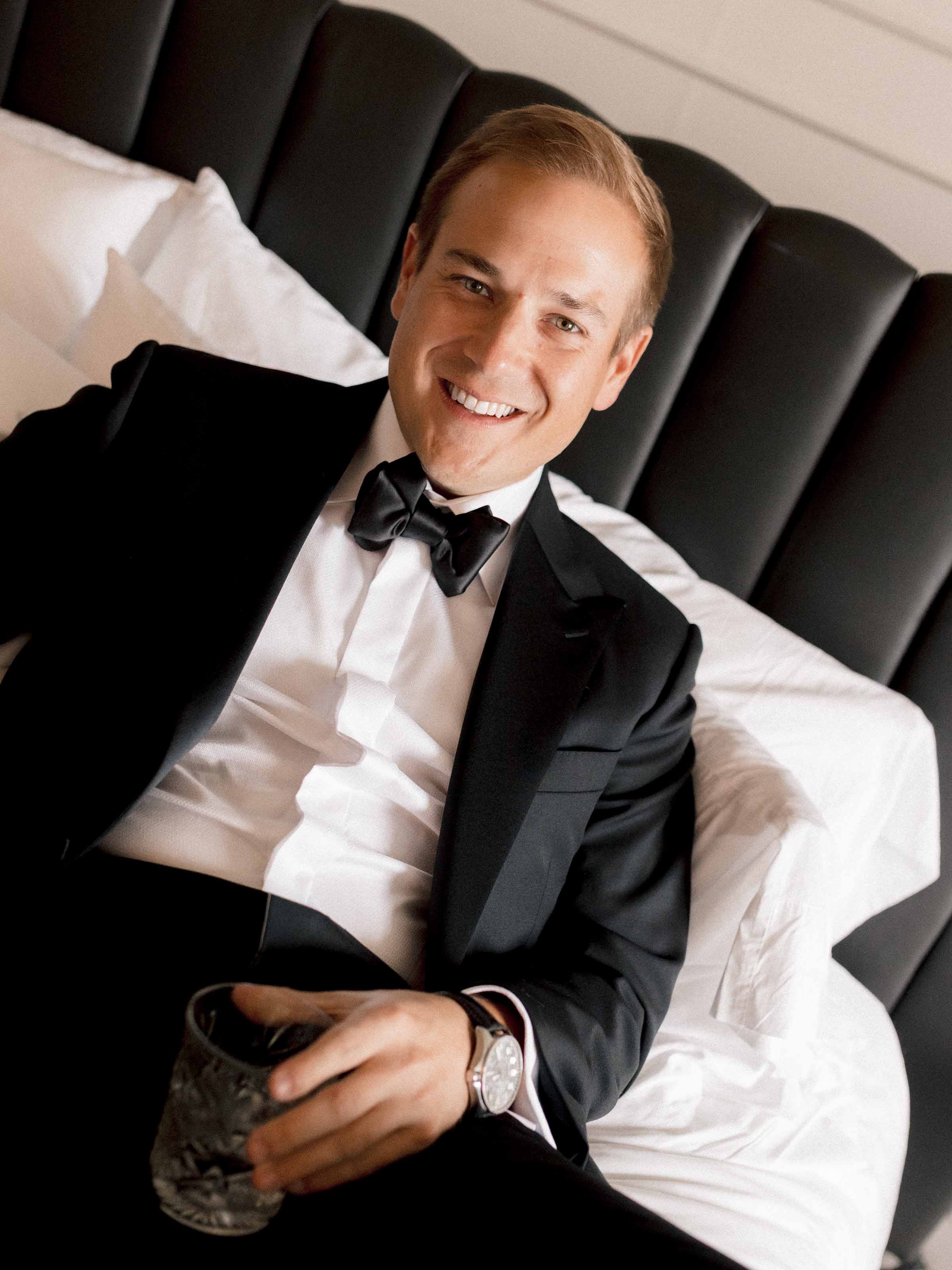 Groom having a drink on bed, Quebec City Wedding