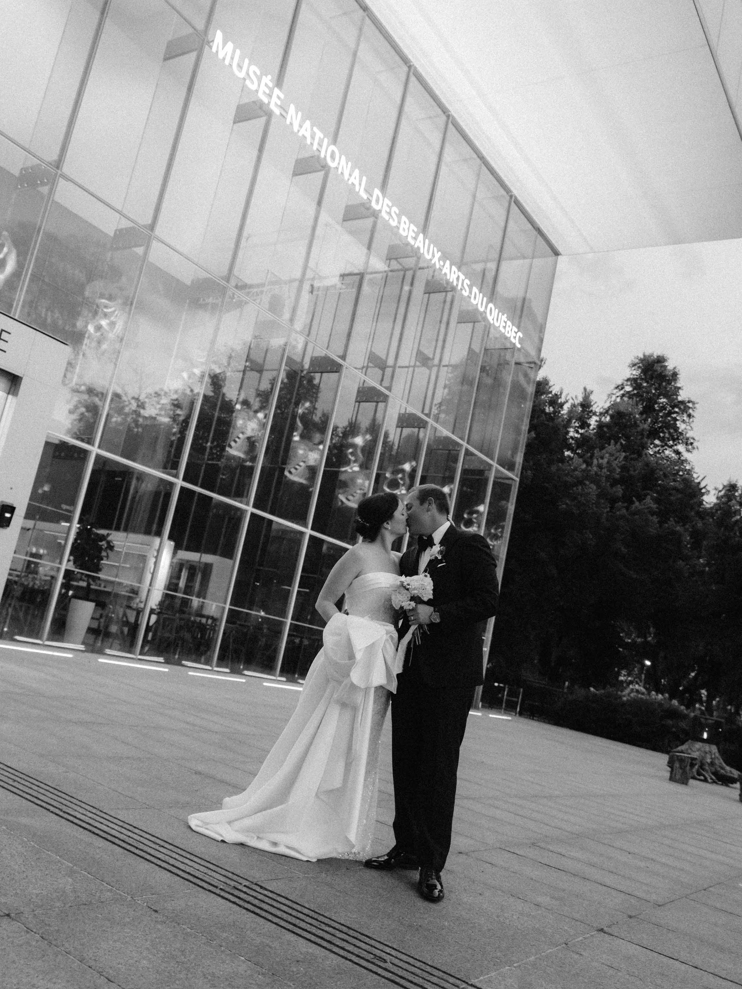 Couple devant la façade vitrée du Musée national des beaux-arts, noir et blanc, Québec