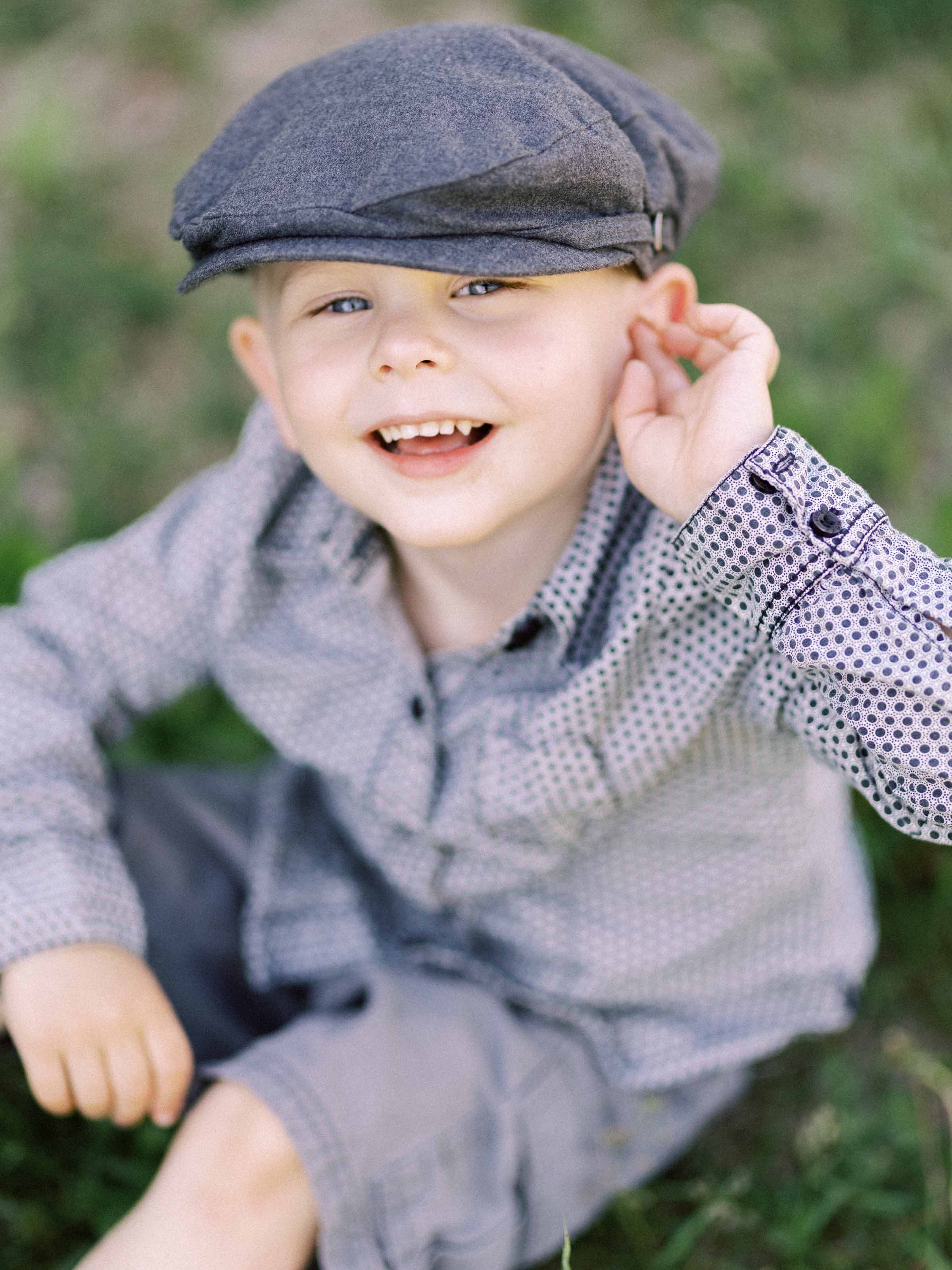Jeune garçon portant une casquette plate et souriant à l'extérieur, ville de Québec