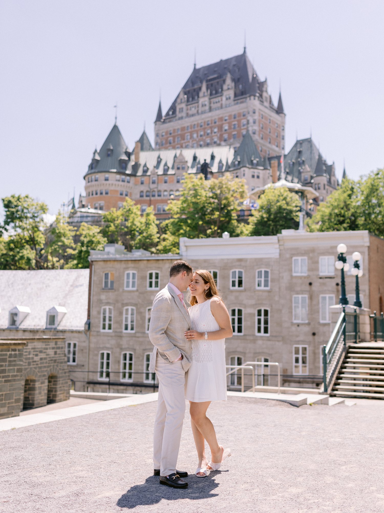 Engaged couple kissing in Old Quebec with the Château Frontenac behind them