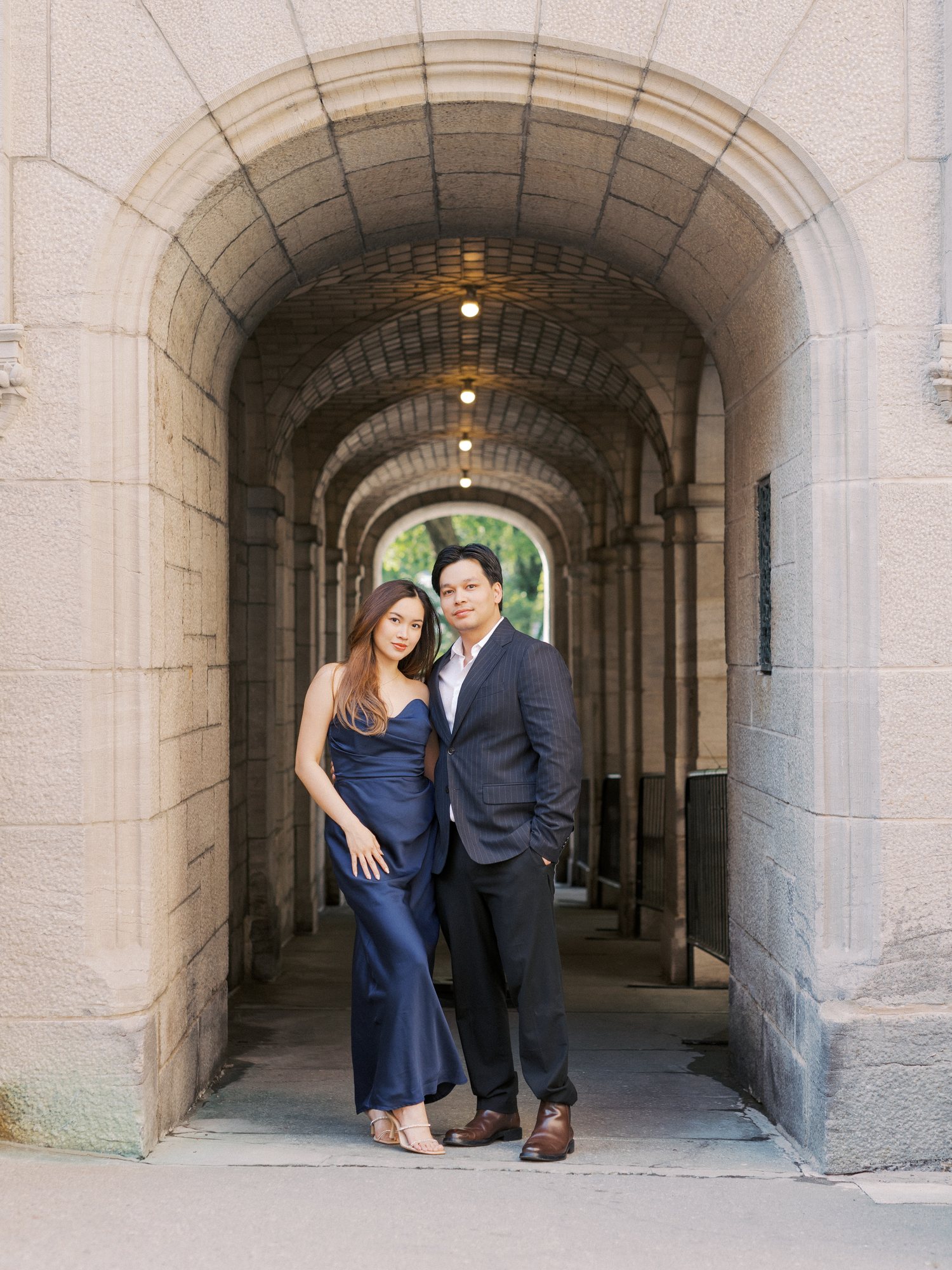 Engaged couple standing in a long arched stone passage in Old Quebec