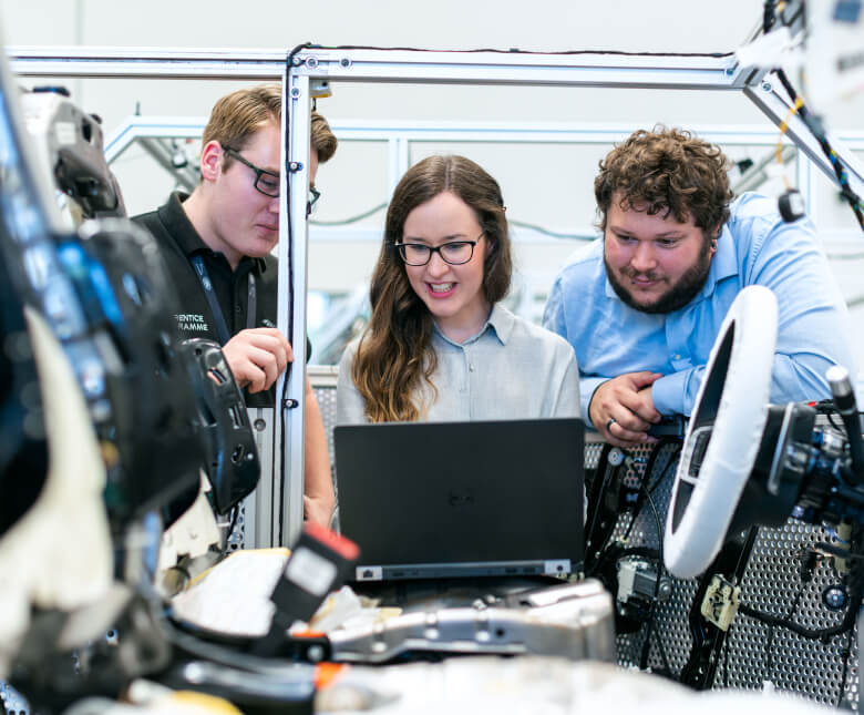 Team von Ingenieuren, das die Anwendungsdaten eines Dashboards an einer industriellen Produktionslinie betrachtet