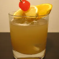 whiskey sour with orange slices and a cherry