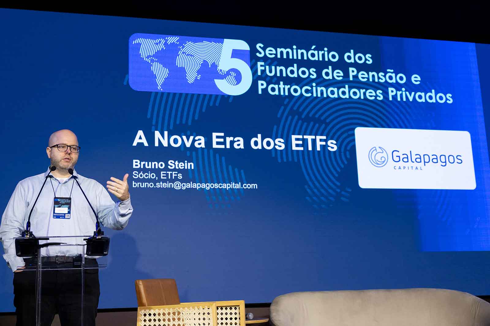 Palestra em seminário com Bruno Stein no palco, ao lado de um pódio, durante evento “Seminário dos Fundos de Pensão e Patrocinadores Privados 5” com o tema “A Nova Era dos ETFs”, na Galapagos Capital.