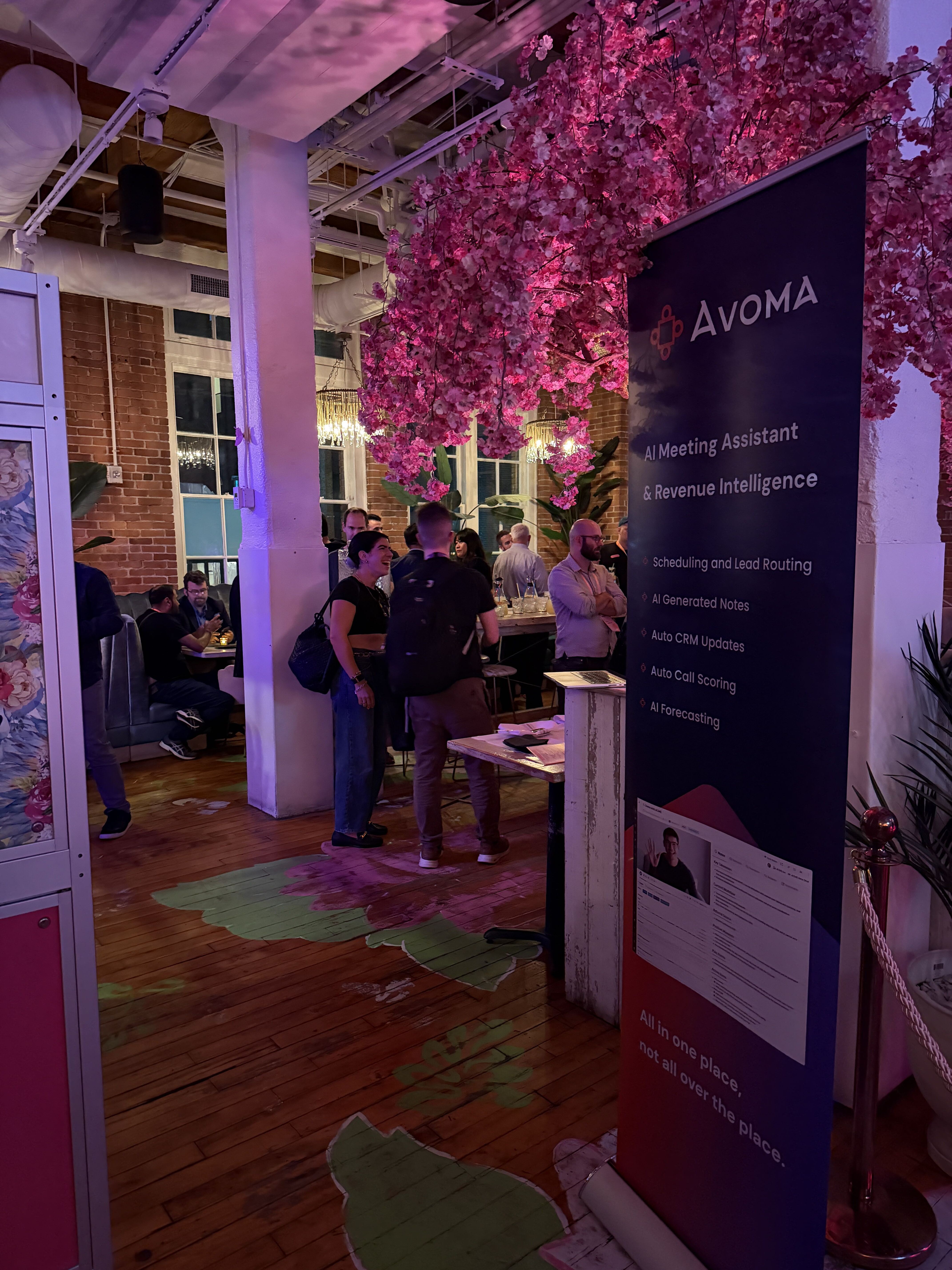 Avoma dinner banner in front of the pink flower installation at UNBOUND 2026